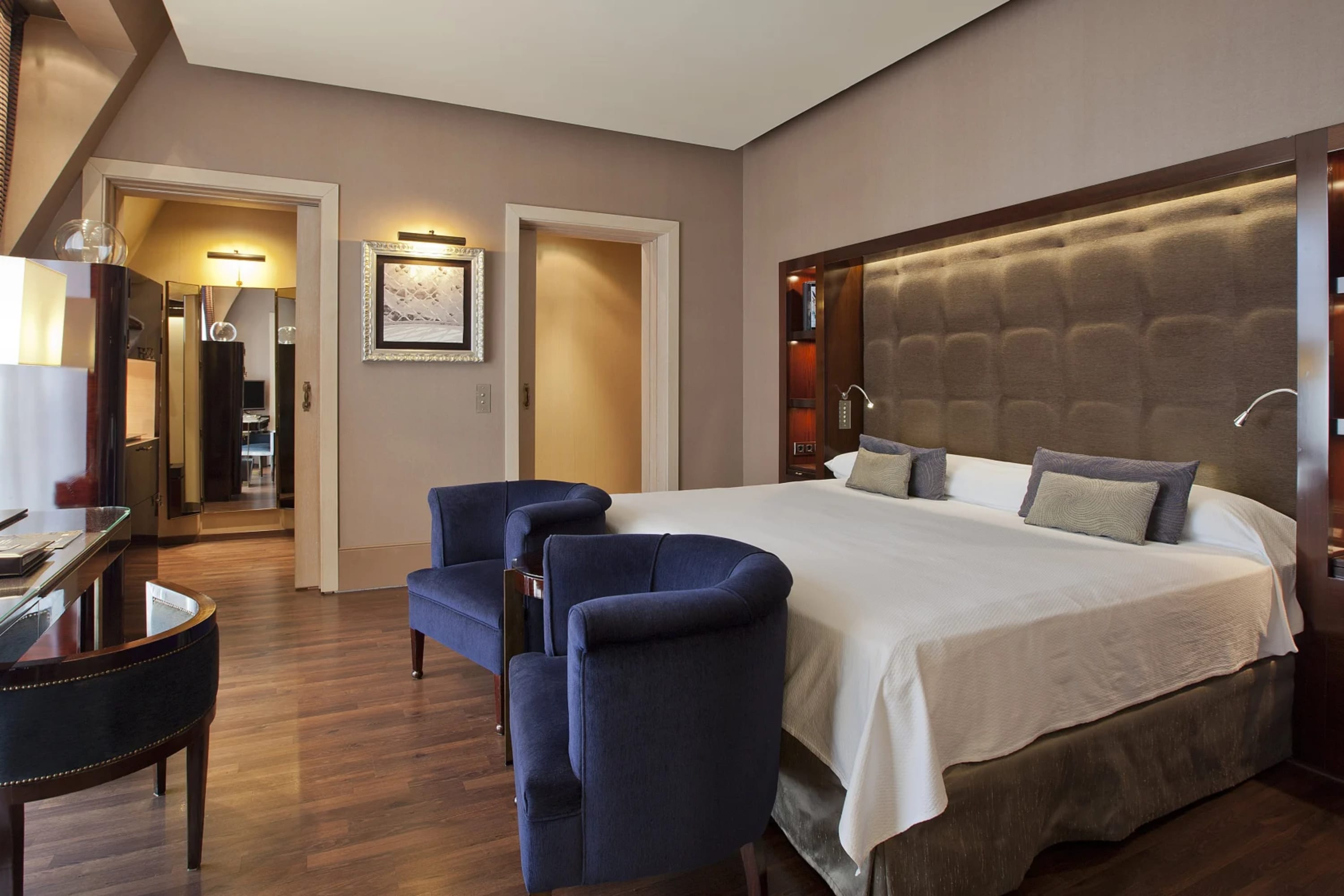 Sophisticated and spacious hotel room with contemporary decor, bold but classy pops of color and high-end vintage furnishings
