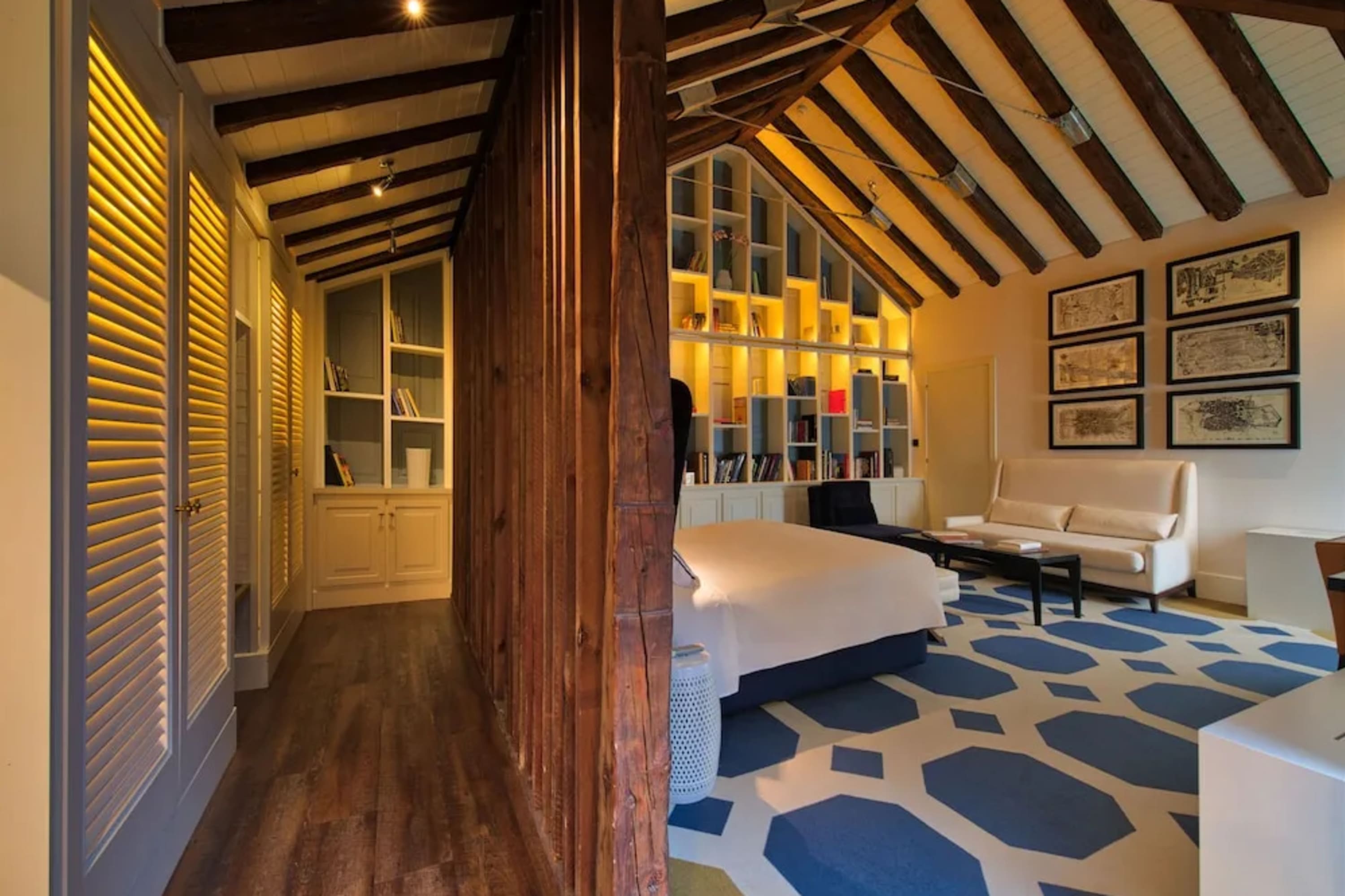 Chic suite with vaulted ceilings, abstract carpet and hardwood, eclectic decor and lots of local art