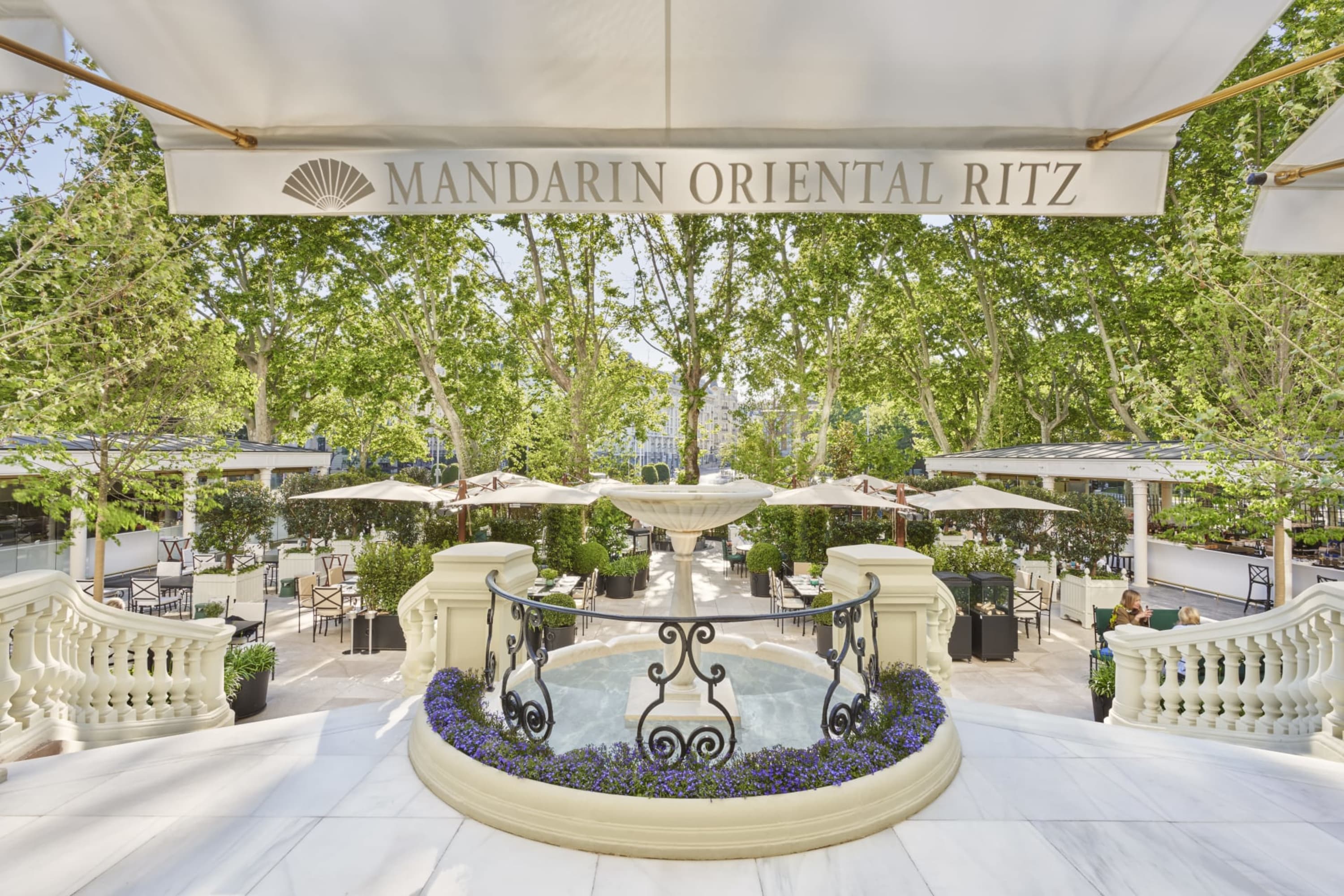 Elegant outdoor seating area in Retiro Park below a grandiose staircase