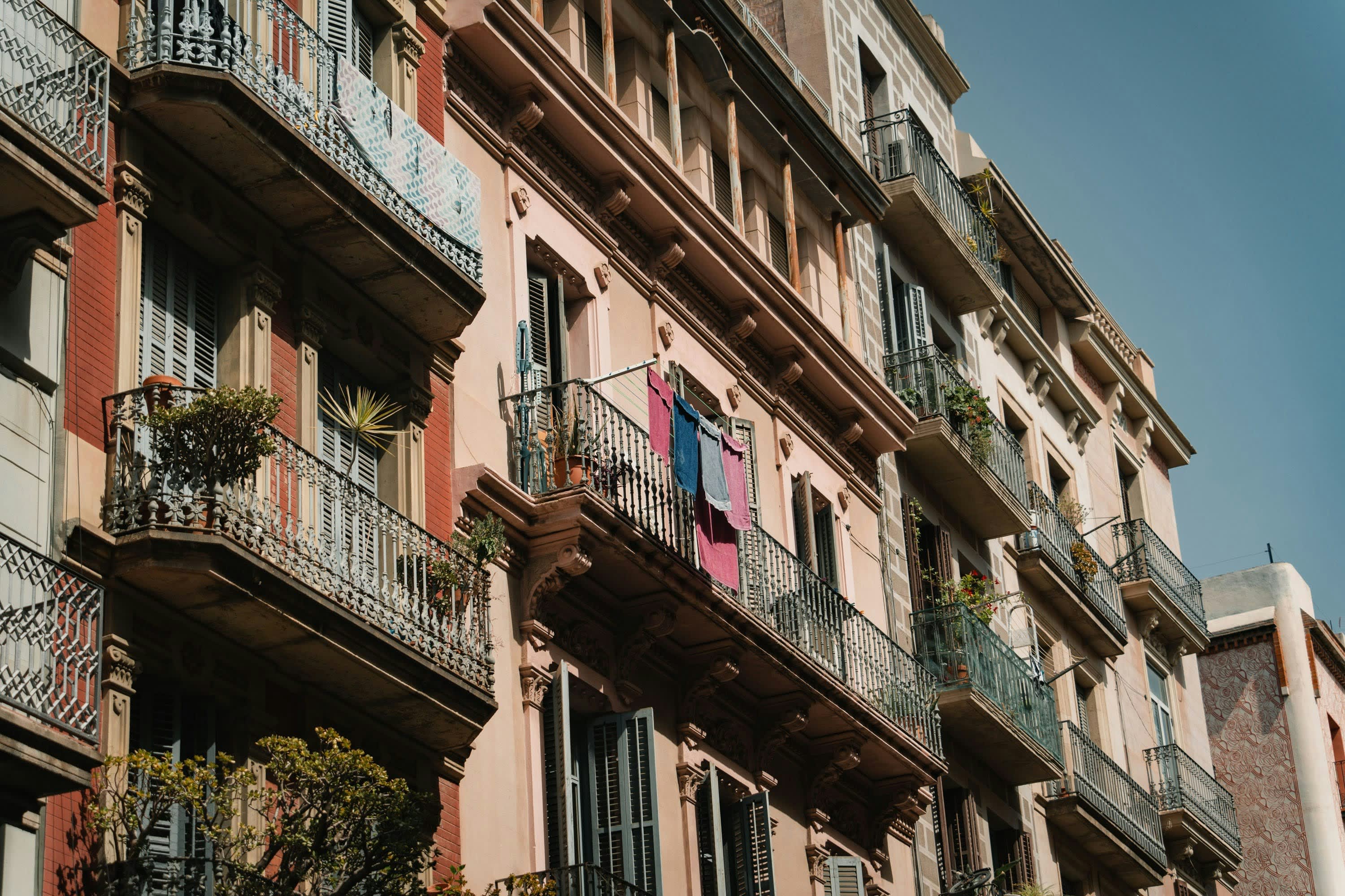 Townhomes with wrought iron balconies filled with tenants' belongings