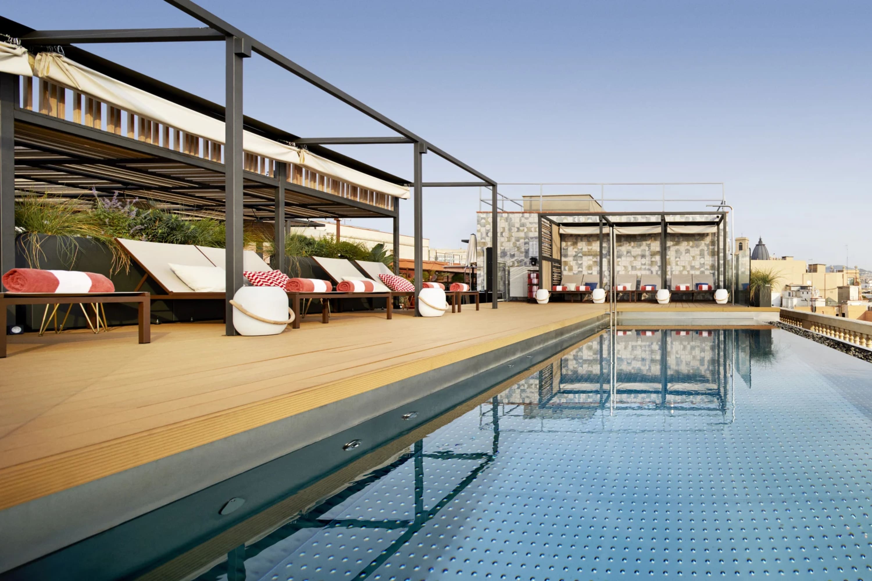 Chic rooftop space with a lengthy pool and view of Barcelona's historic skyline
