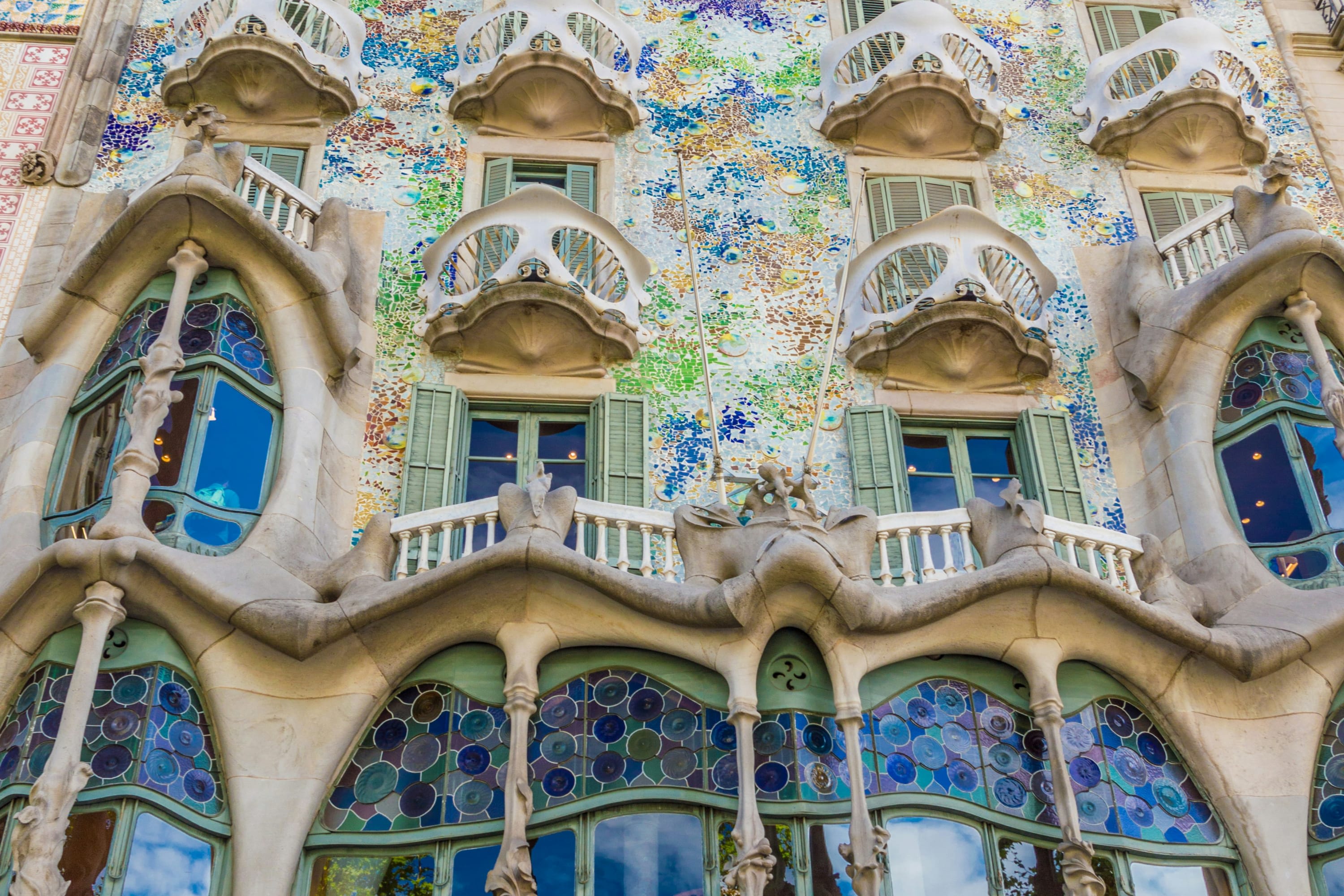 The facade of Casa Batlló, a famous Gaudi work in Barcelona with an organic appearance and colorful stained glass windows