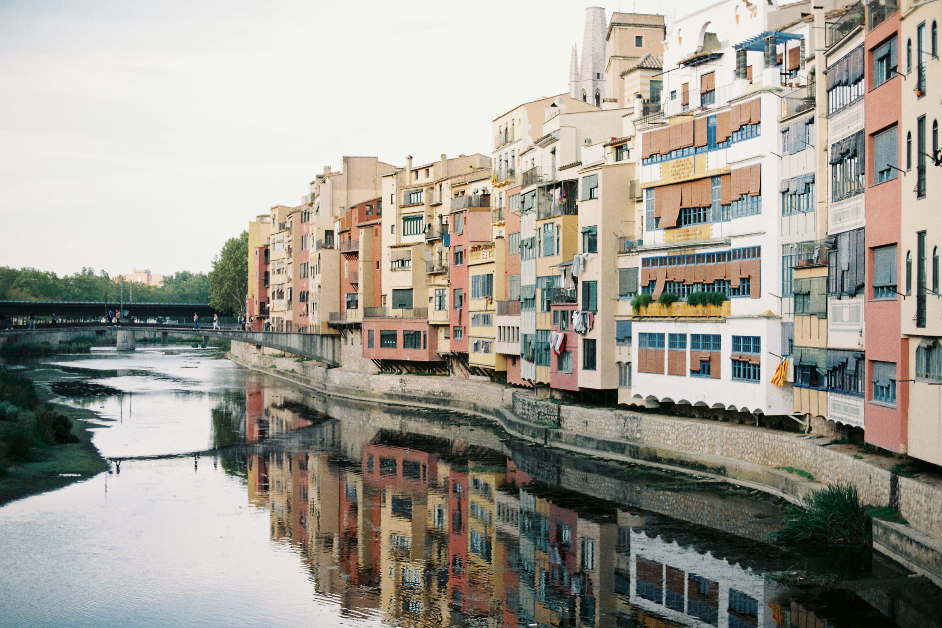 On a hazy day: pastel-colored townhomes line a canal with calm water