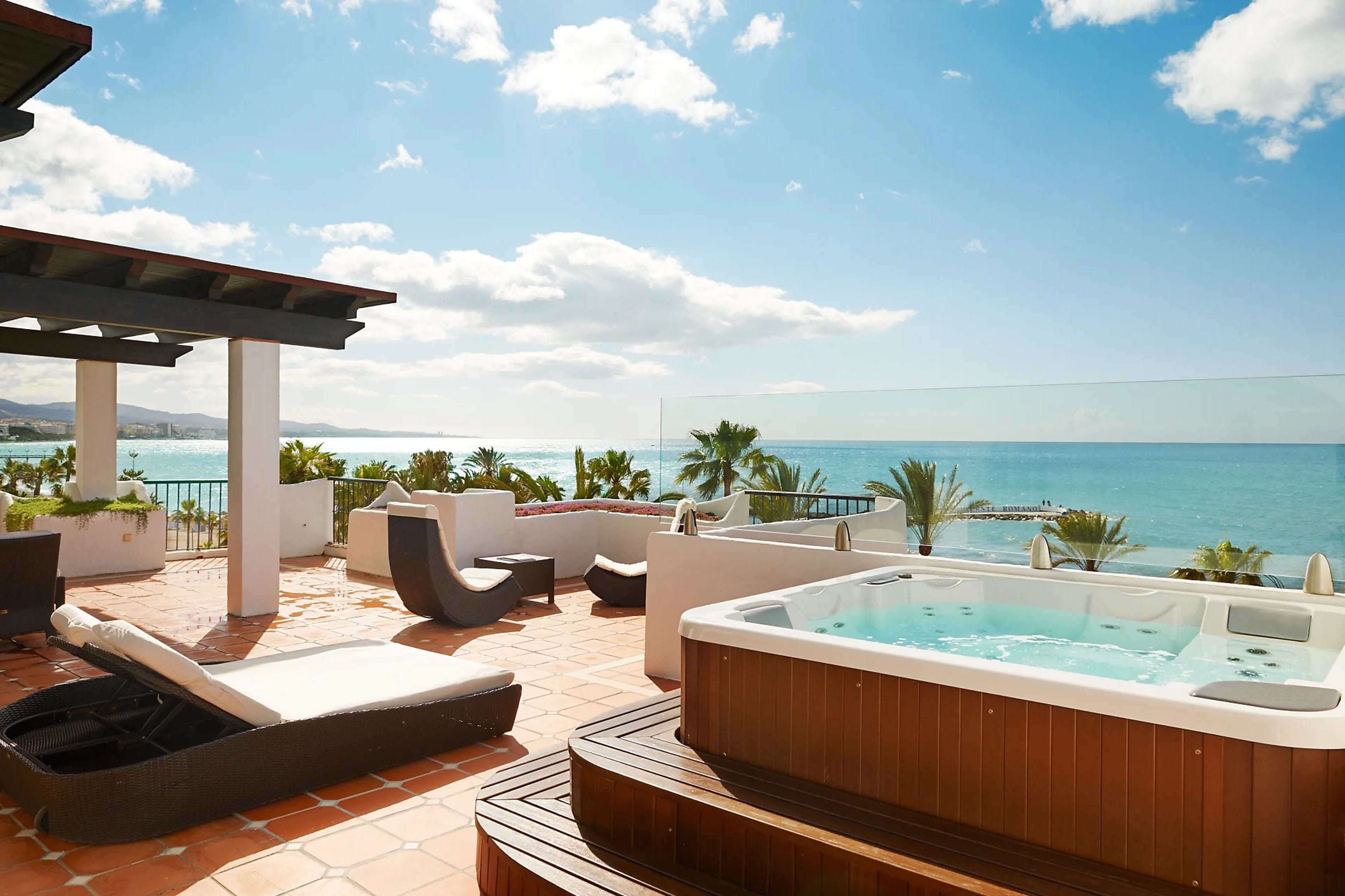 A posh terrace space with a large hot tub and panoramic view of the Mediterranean sea and Marbella