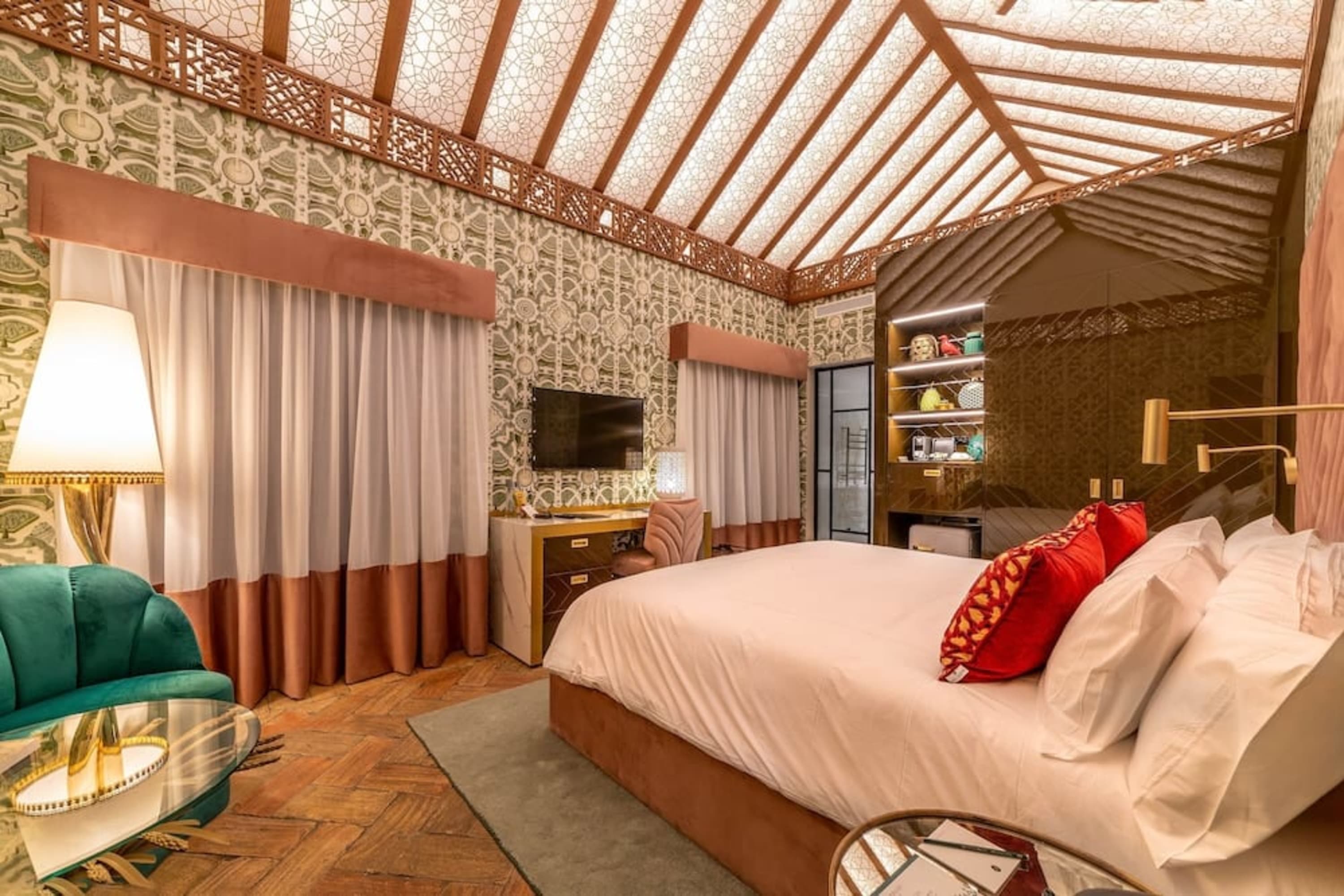 Artful hotel room with rustic parquet flooring, wallpaper with an intricate pattern, eclectic decor and a natural color palette interrupted by bold colors