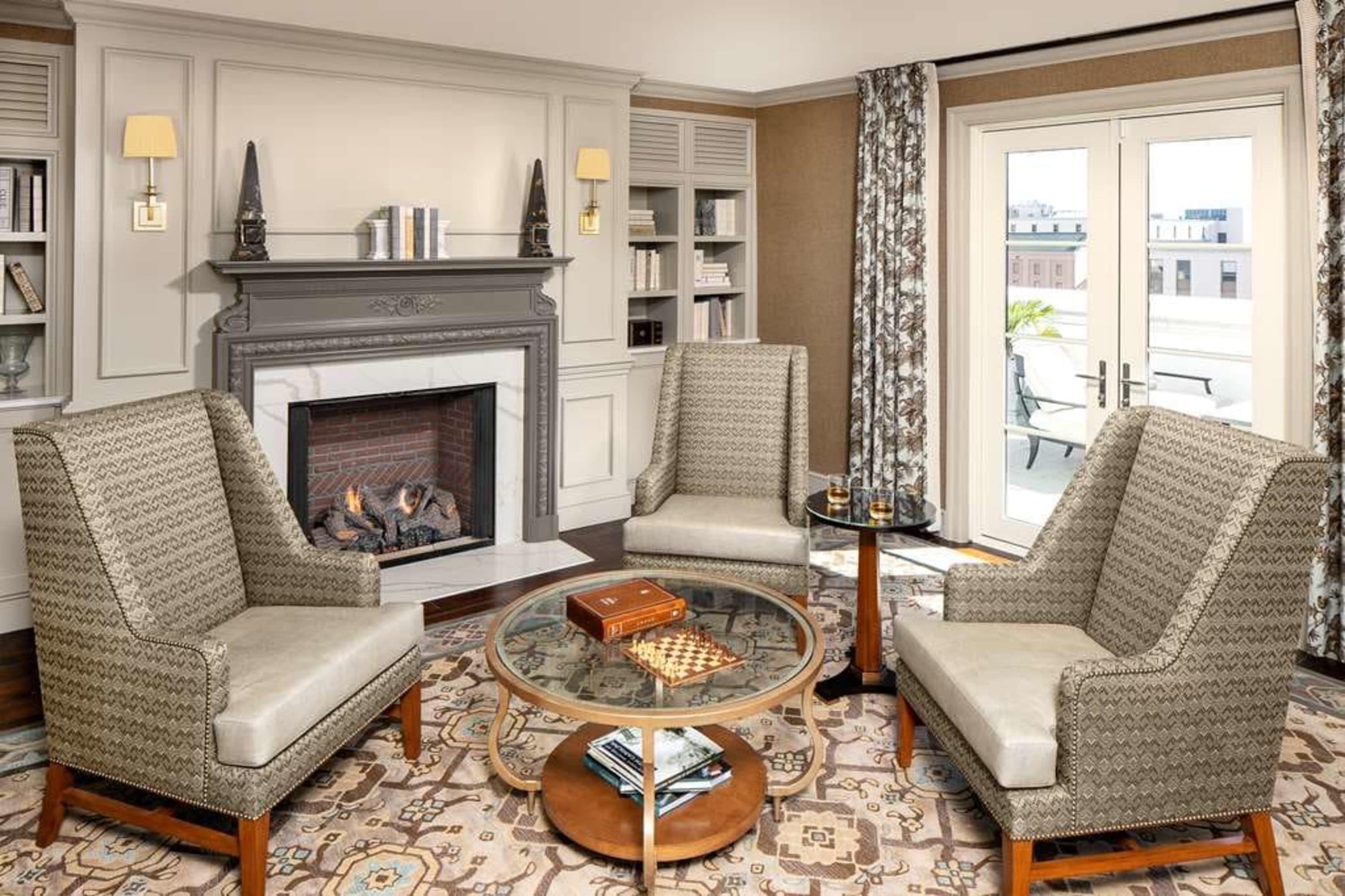 Classic Southern decor fills a cozy living room with a fireplace and balcony access
