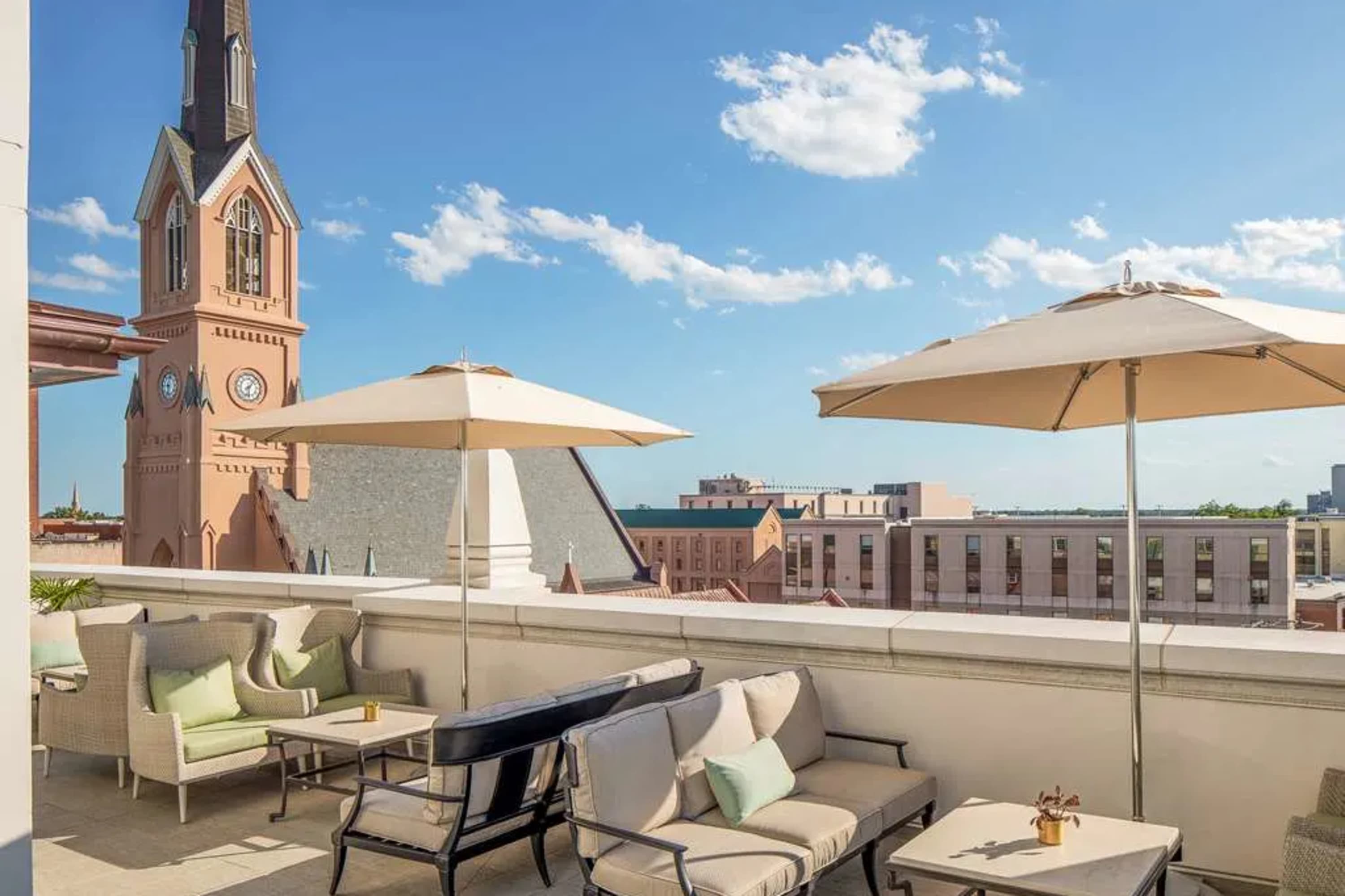 Chic rooftop scene with a view of historic Charleston and table settings with umbrellas