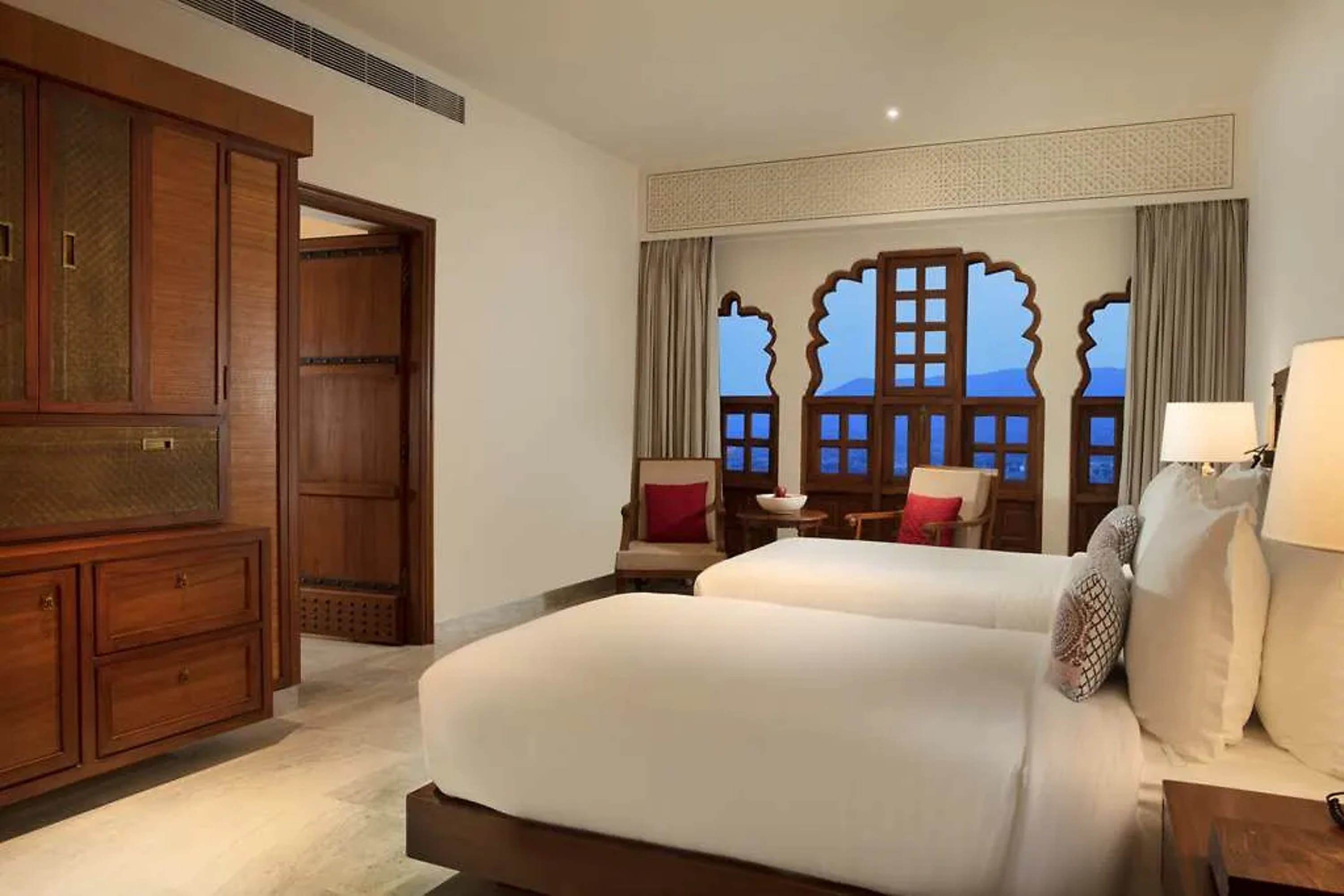 A minimalist but pleasant hotel room with Indian accents and hardwood furniture