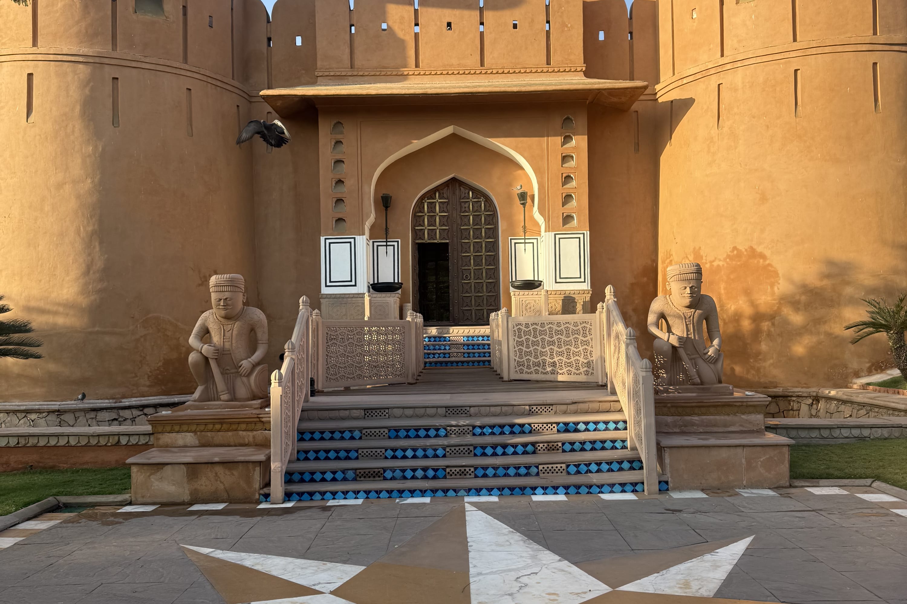 Rajasthani architecture: two prominent statues guard either side of a grand, castle-like entrance