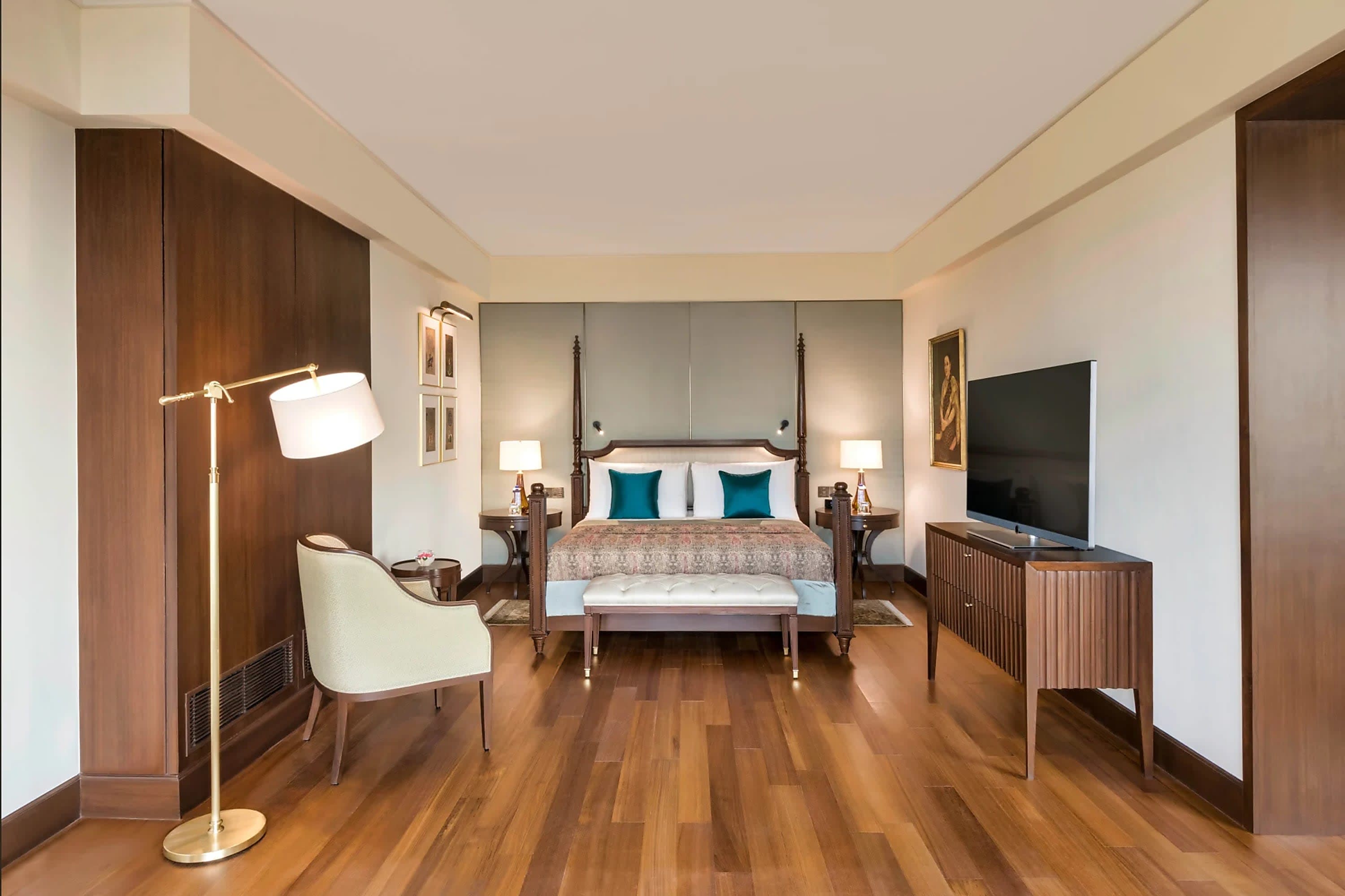 Hardwood floors lead to an elegant four-post bed in a room with plenty of space