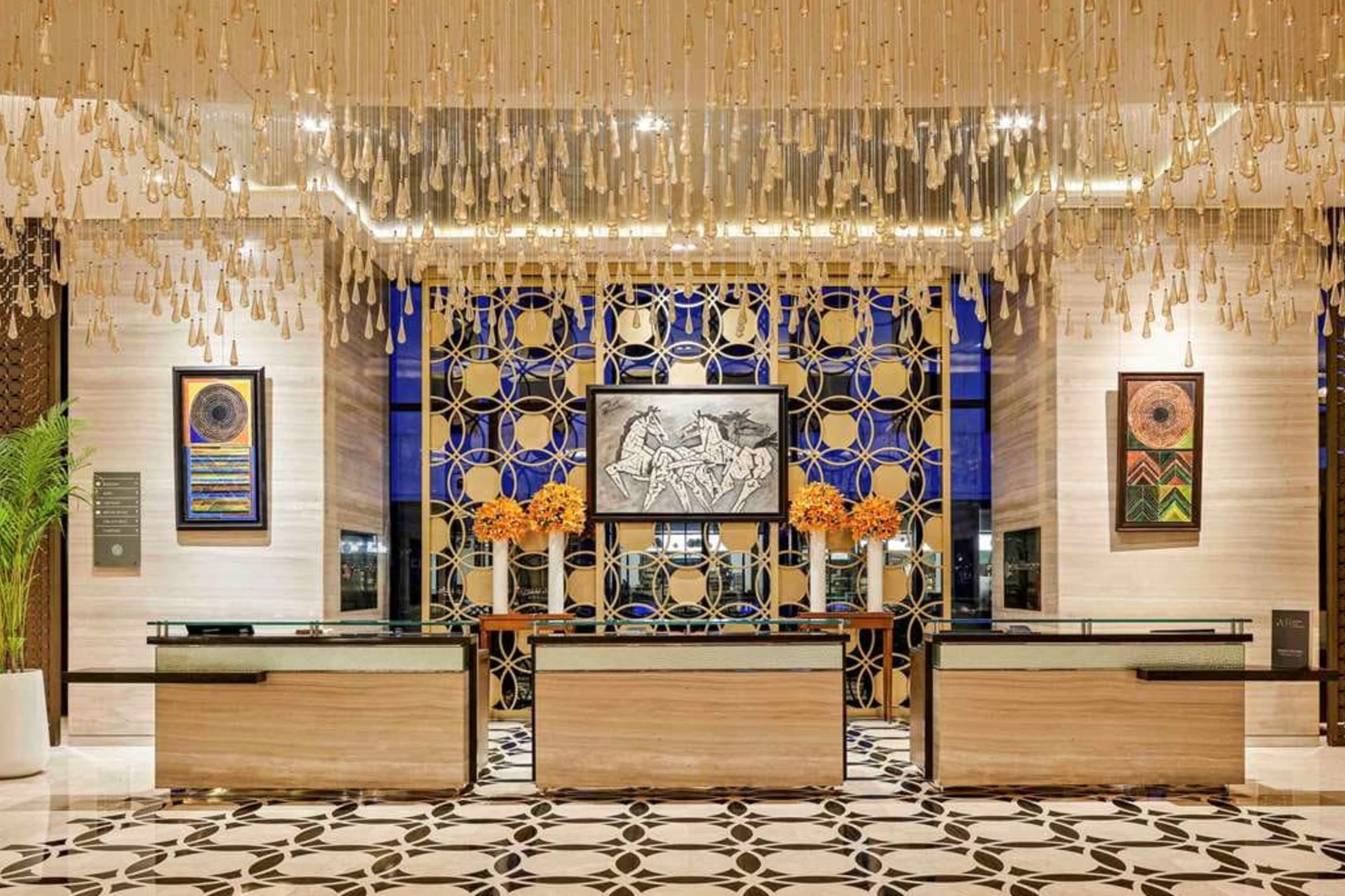 Elegant hotel lobby with a mix of Indian and contemporary accents, like geometric tiles and streaming ceiling lights