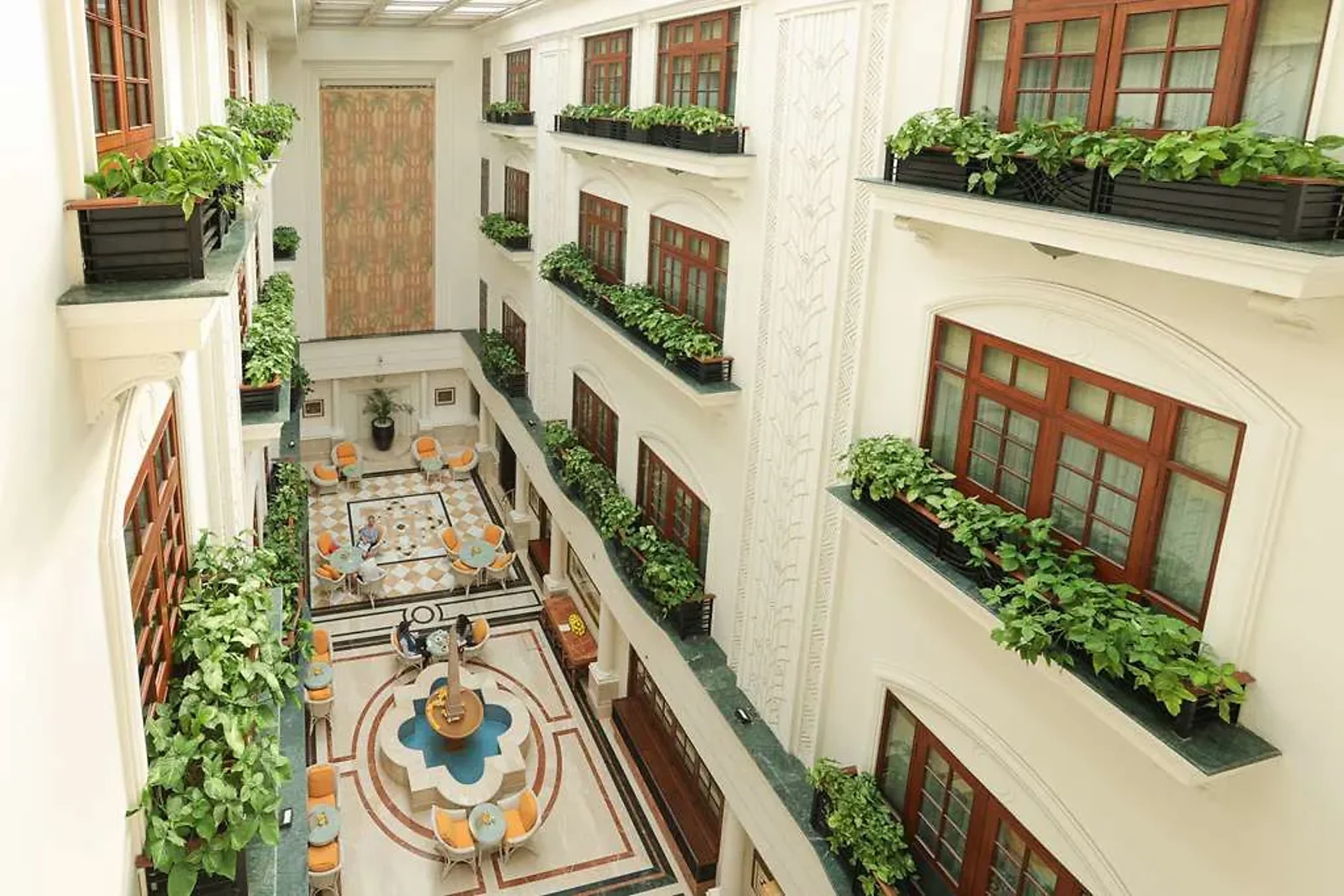 Ornate lobby with greenery hanging off three levels of faux balconies