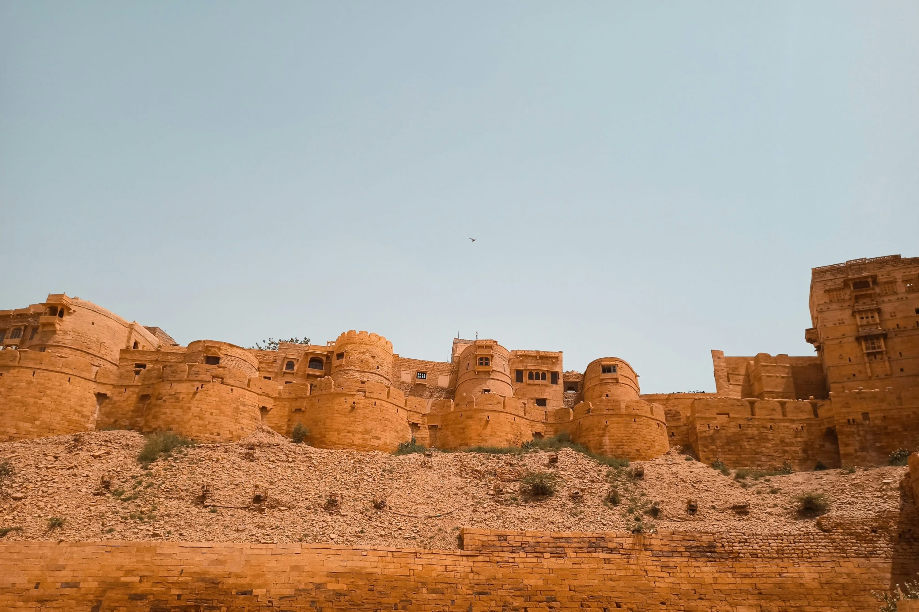 Rough sands lead to an ancient sandstone fortress amid dusty conditions