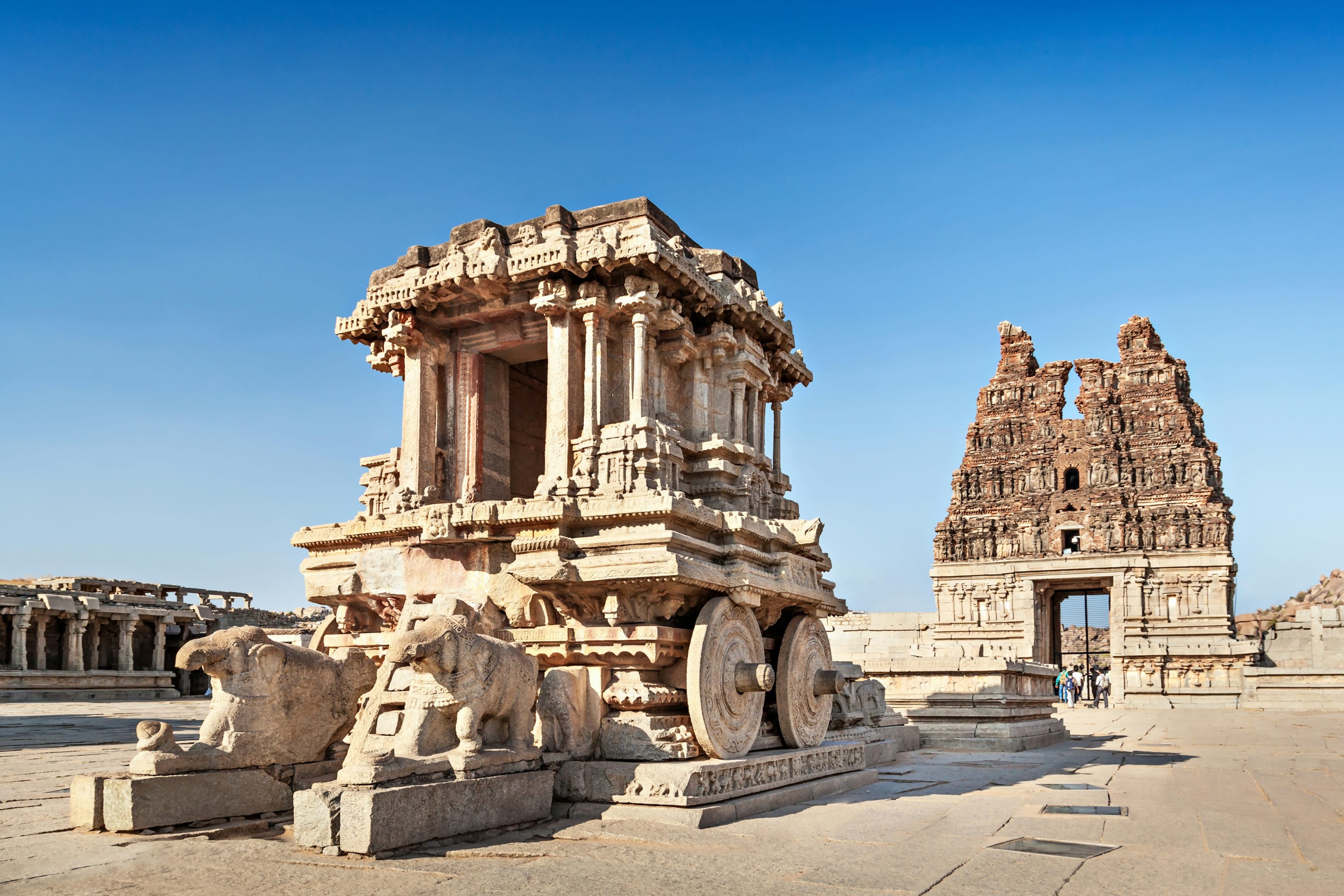 Stone temples and sculptures of elephants pulling a massive chariot