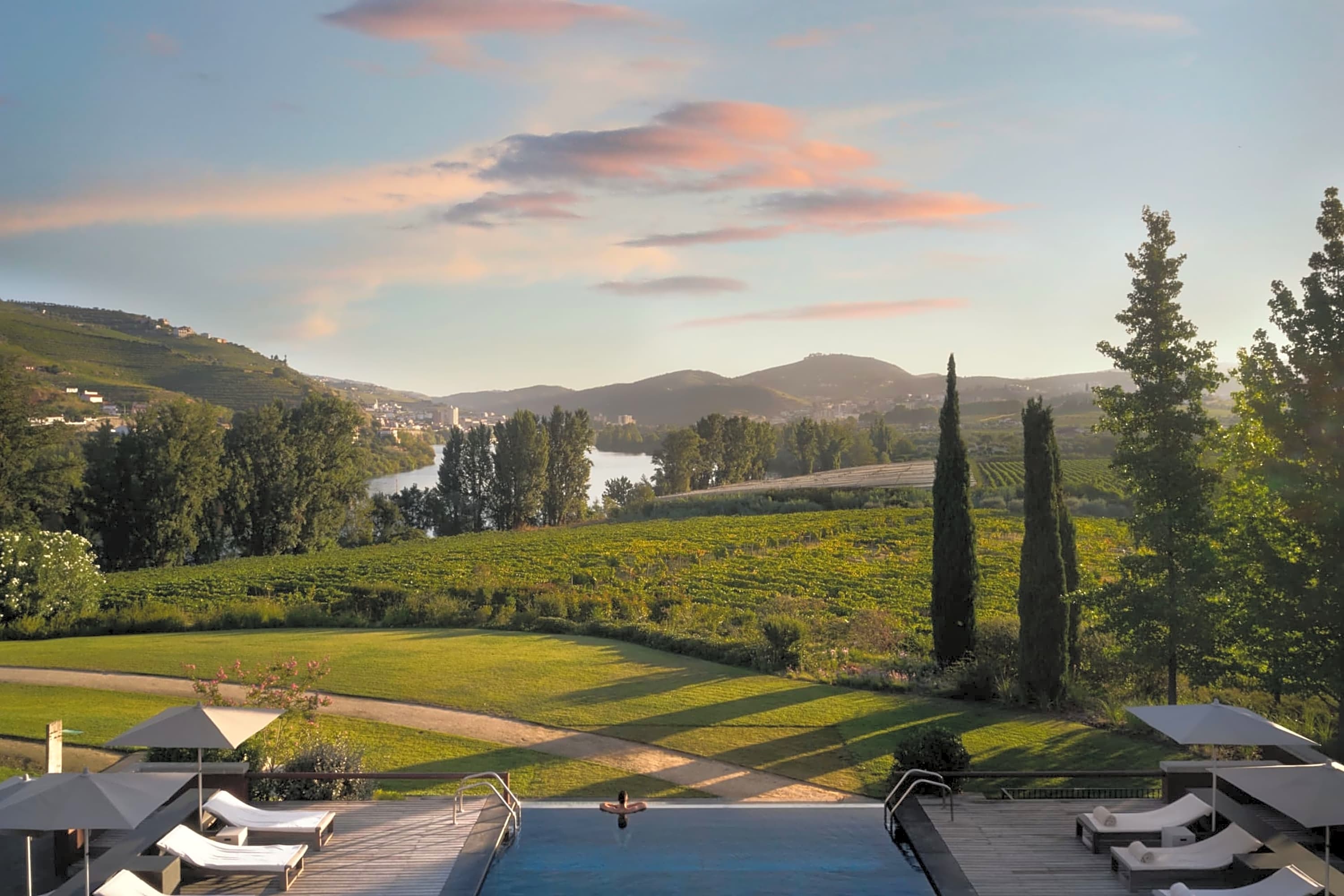 Chic pool area with an infinity edge overlooking Douro Valley vineyards and hills