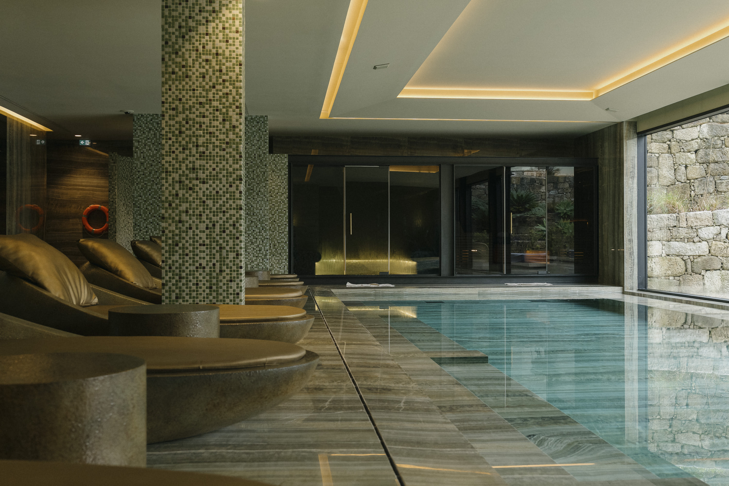 Design-forward pool area with chic loungers before a sleek pool