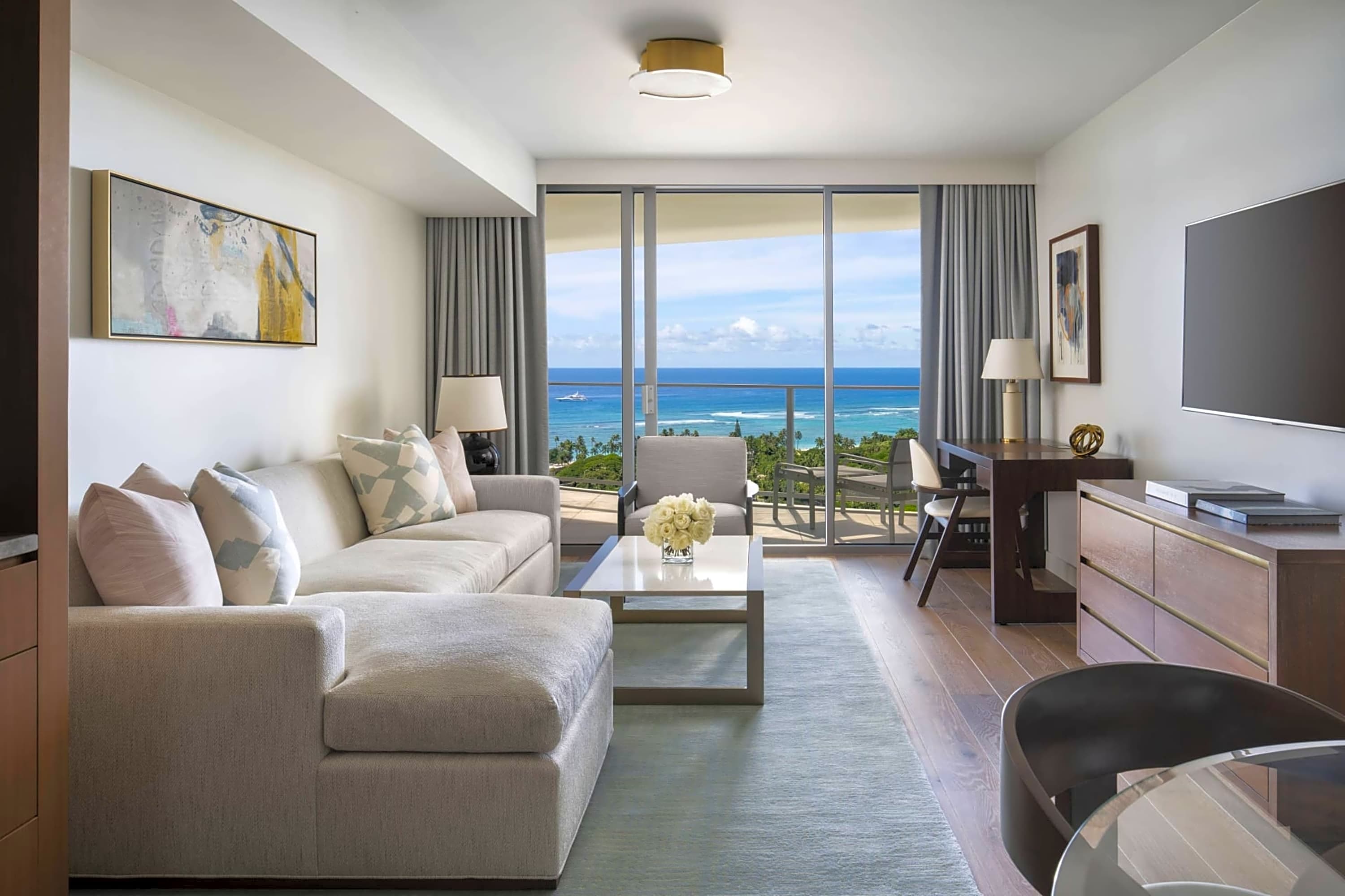 Spacious hotel room with modern amenities and a private balcony with ocean views