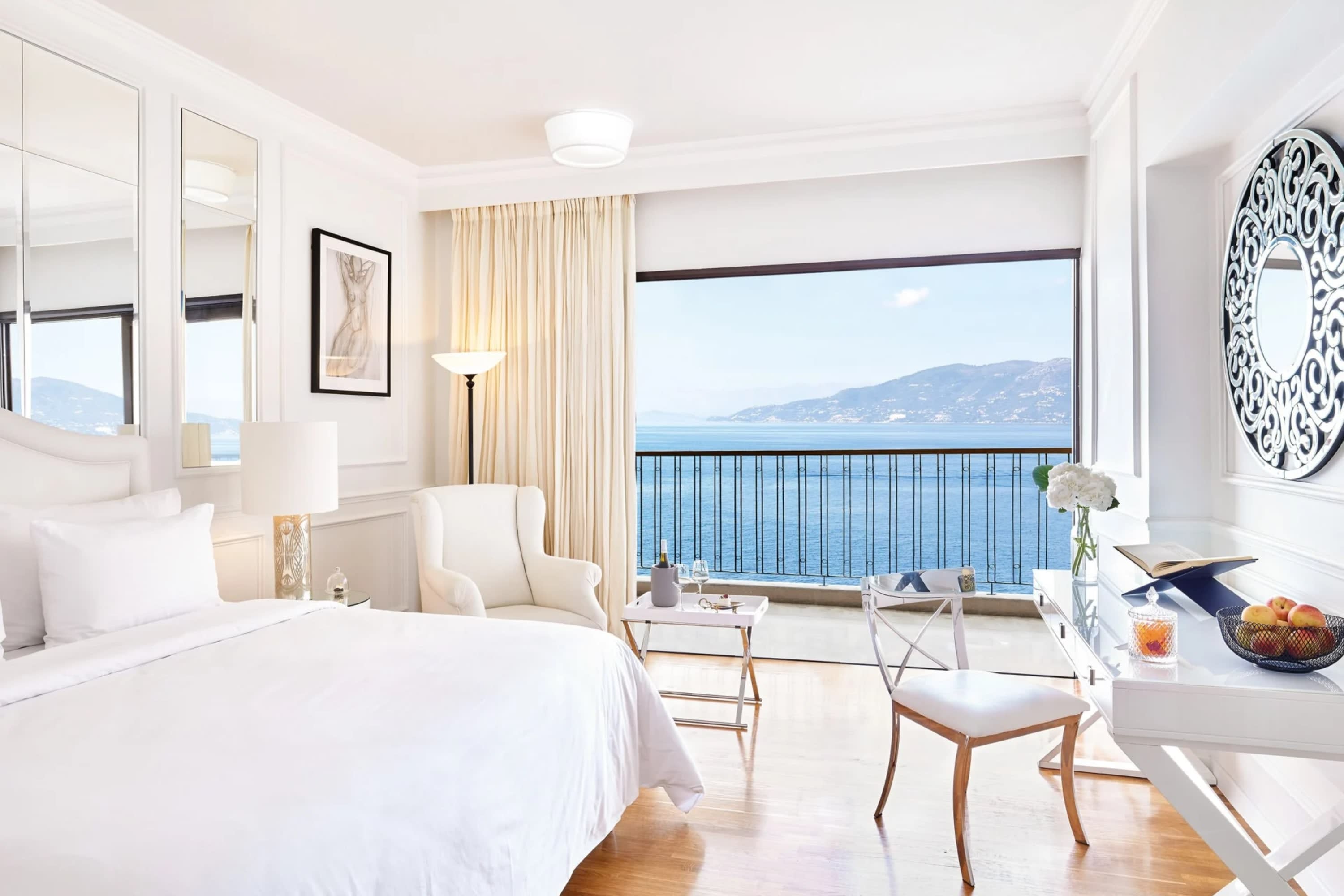 White-washed hotel room with plenty of natural lighting and an open view of the Mediterranean