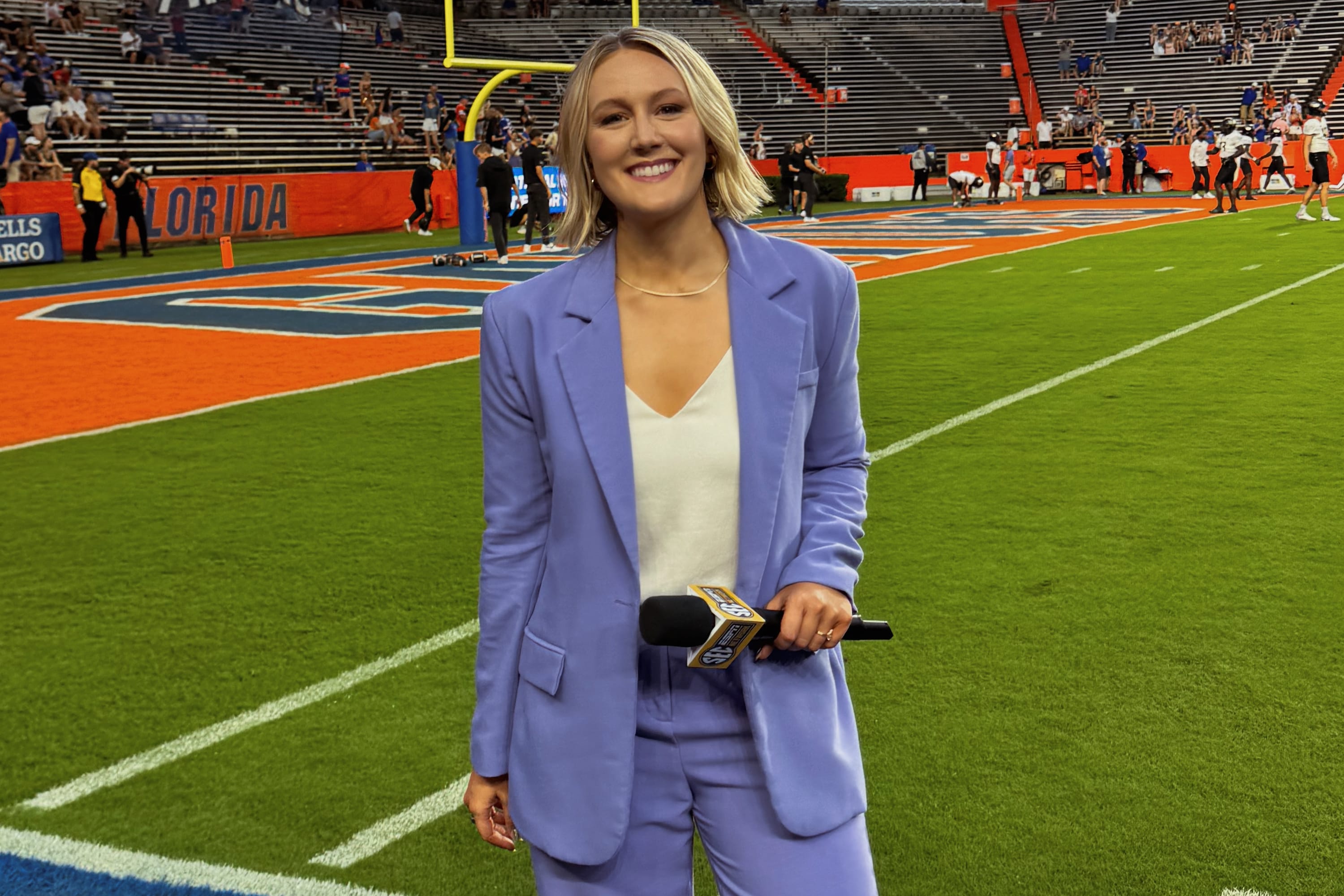 woman reporter standing in a football stadium