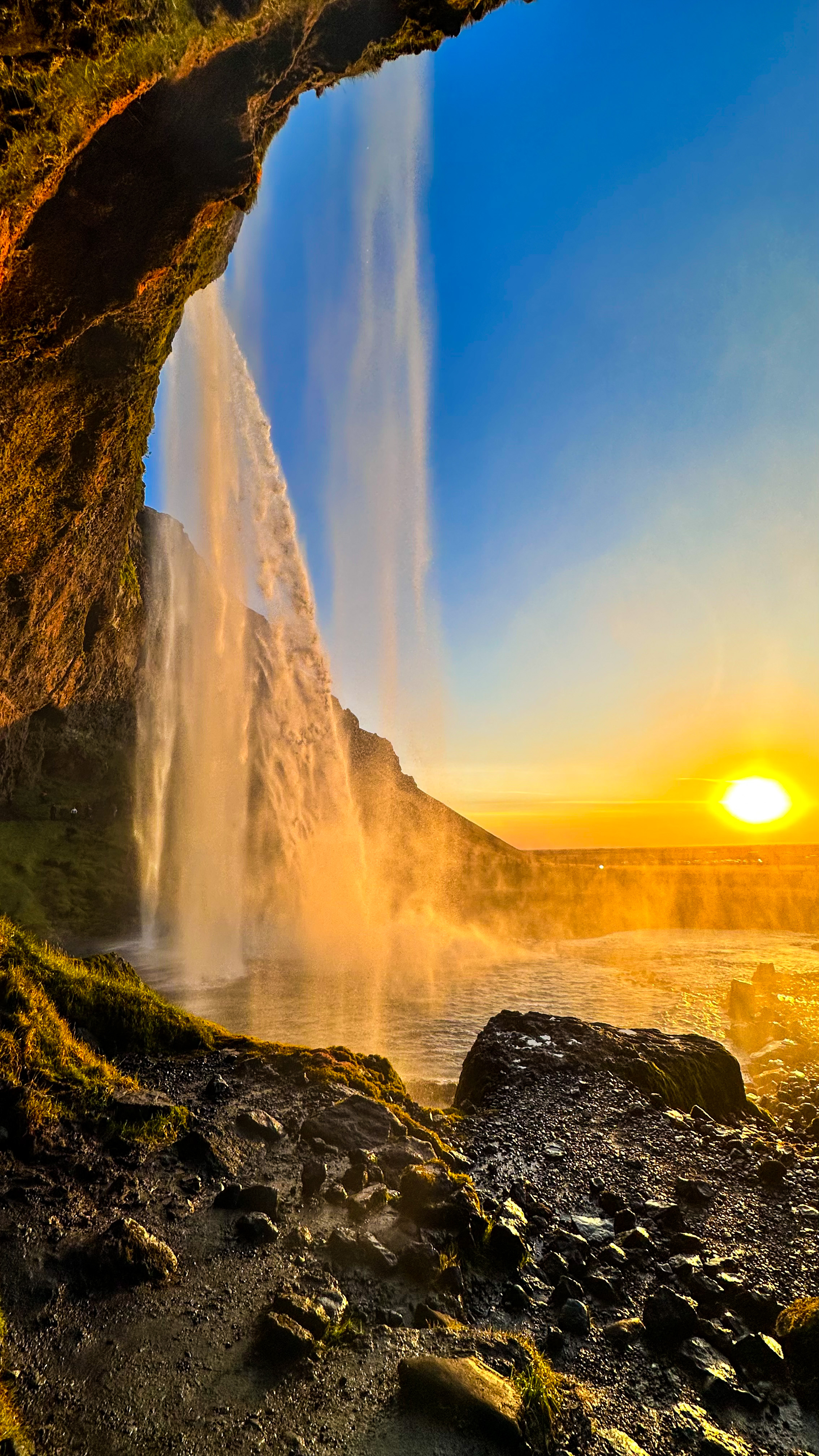 A beautiful picture of a waterfalls from below at sunset.