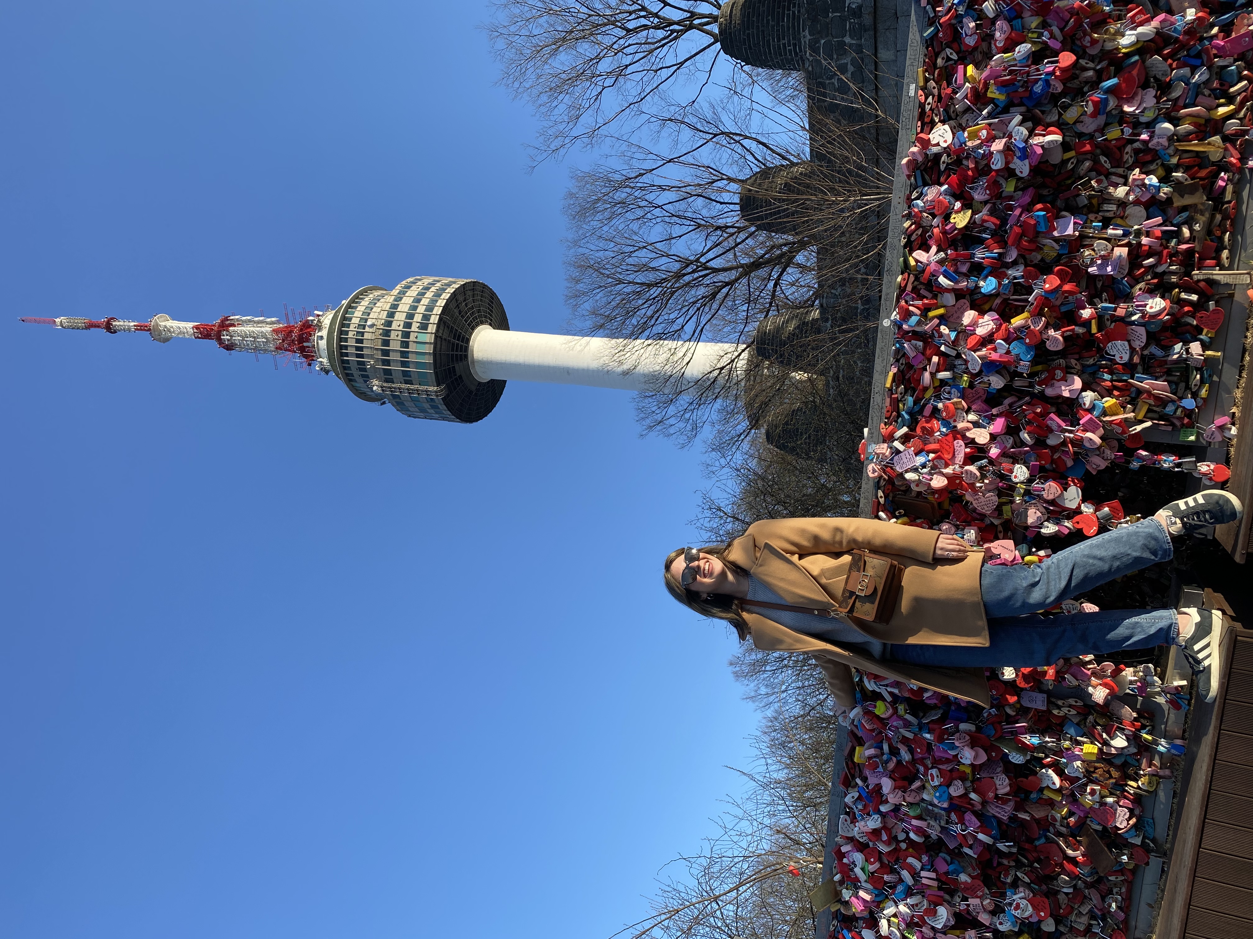 Advisor posing on a bridge with a tall structure in the distance.