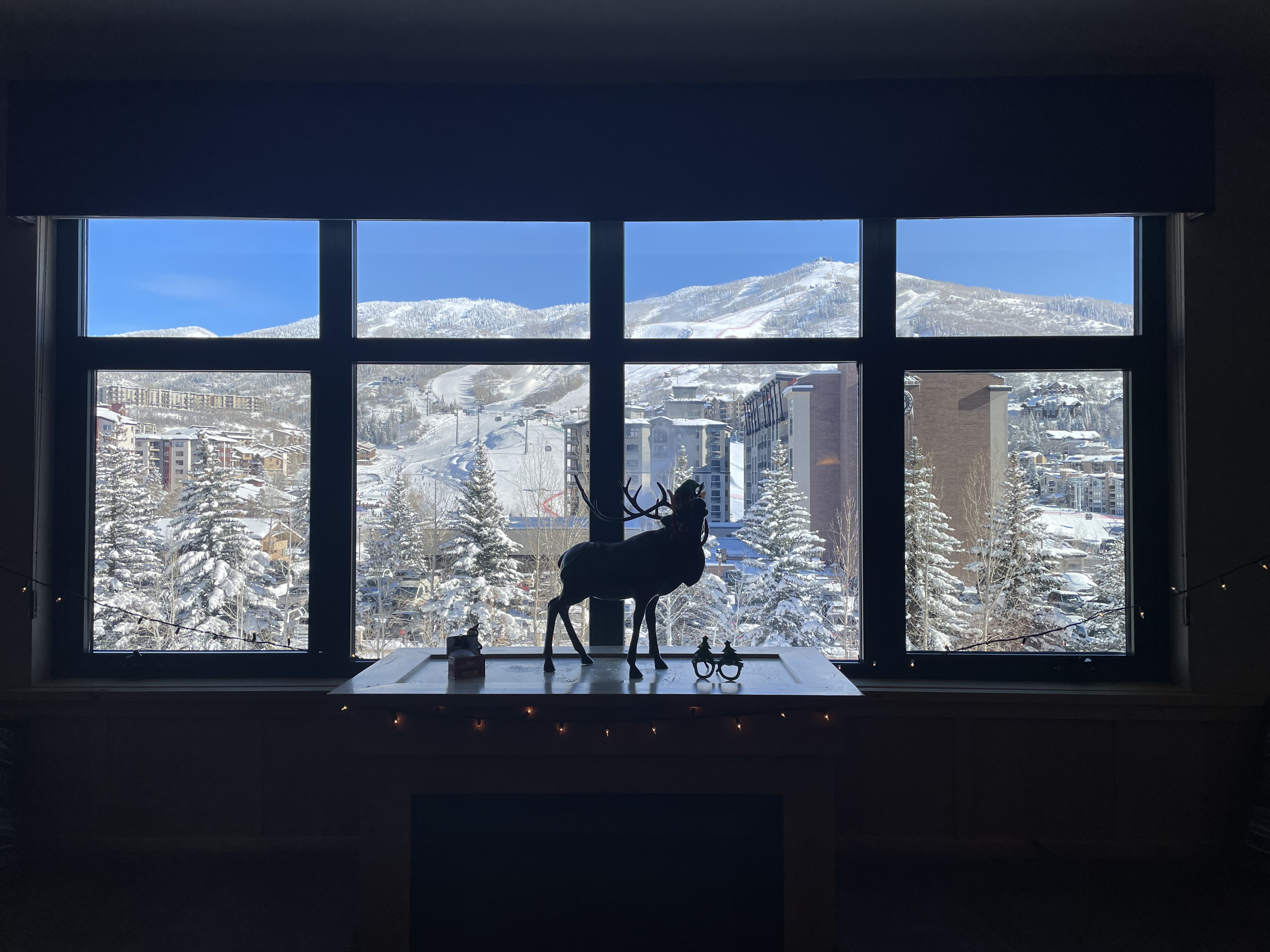 An image of widow with snowy mountains in the distance on a sunny day.