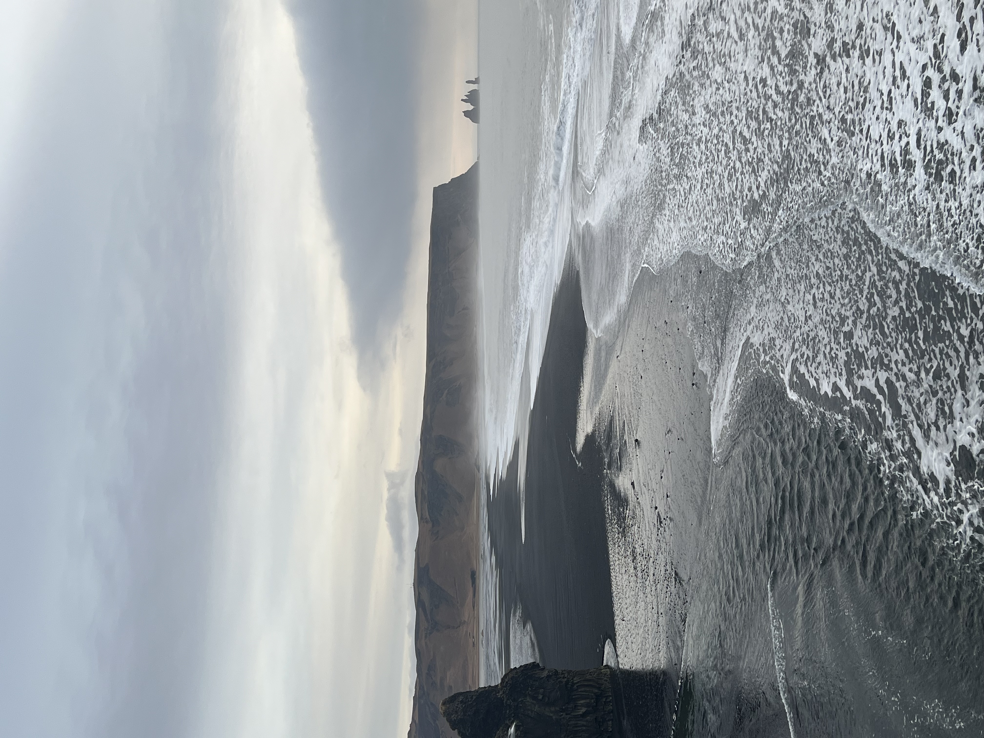 Aerial view of an empty beautiful coastline with cliffs and cloudy skies