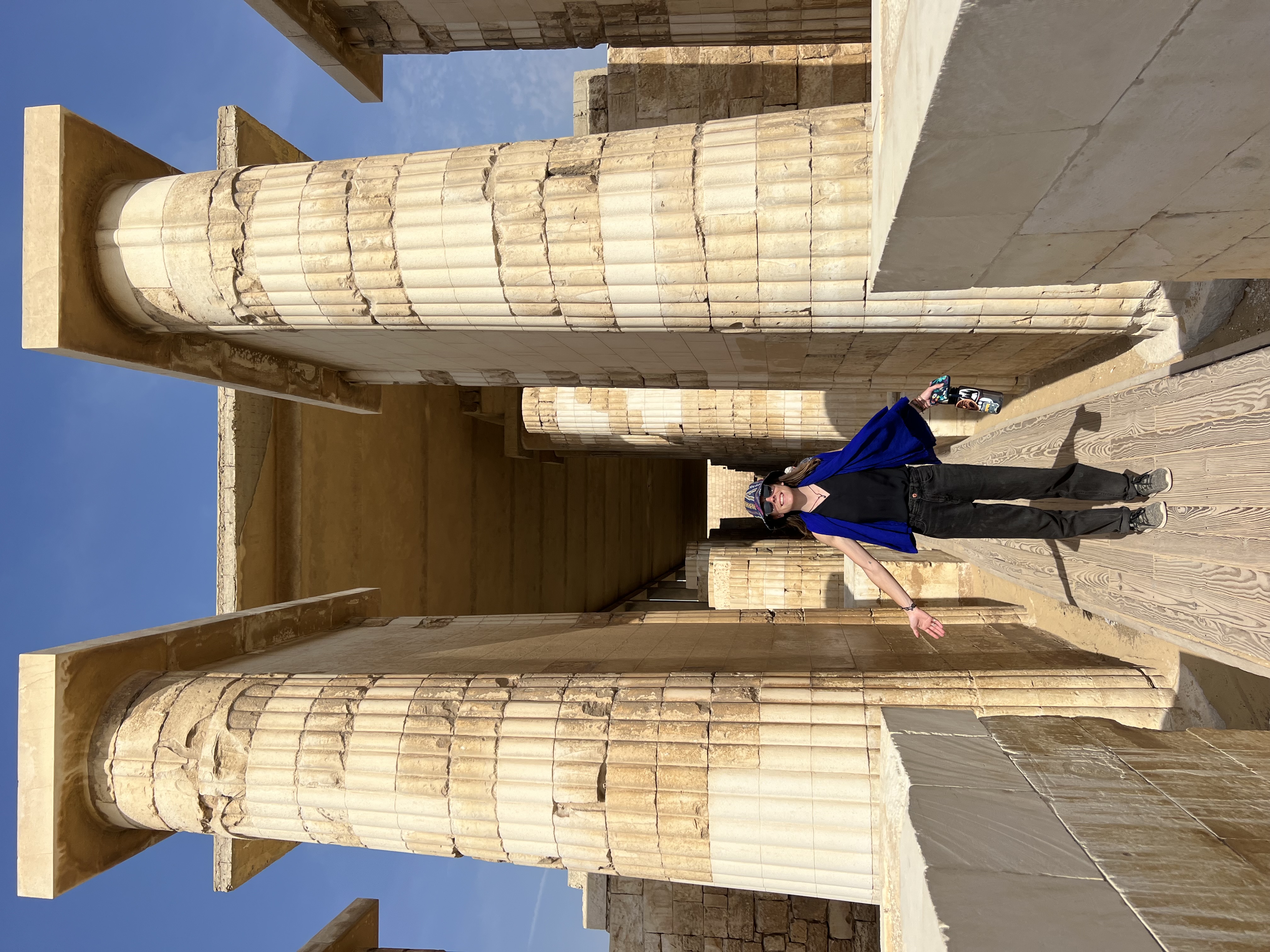 Advisor posing for an image with ancient ruins and columns on a sunny day.