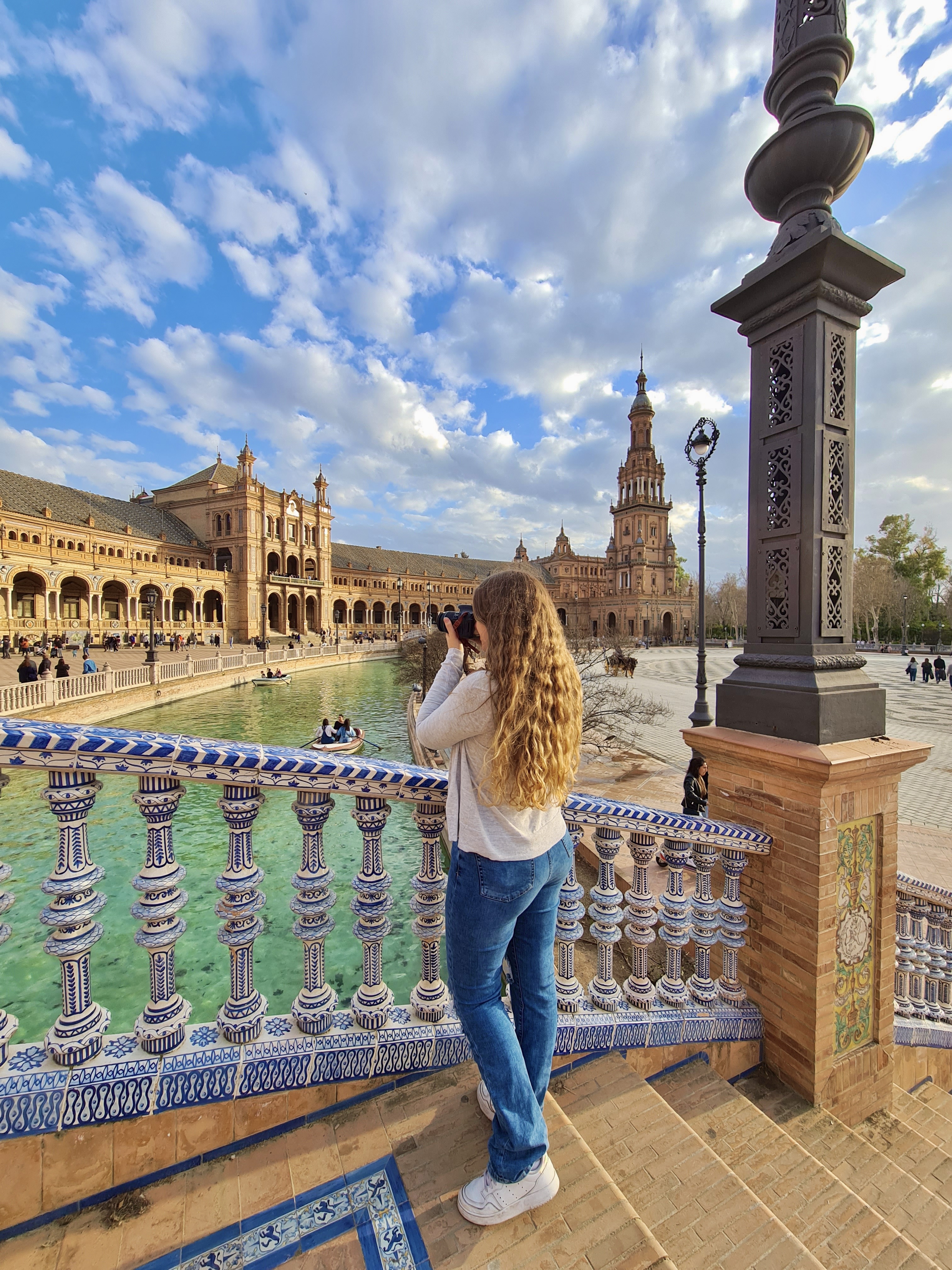 Kaitlin taking a photo from a bridge in Seville’s Plaza de Espana on a sunny day