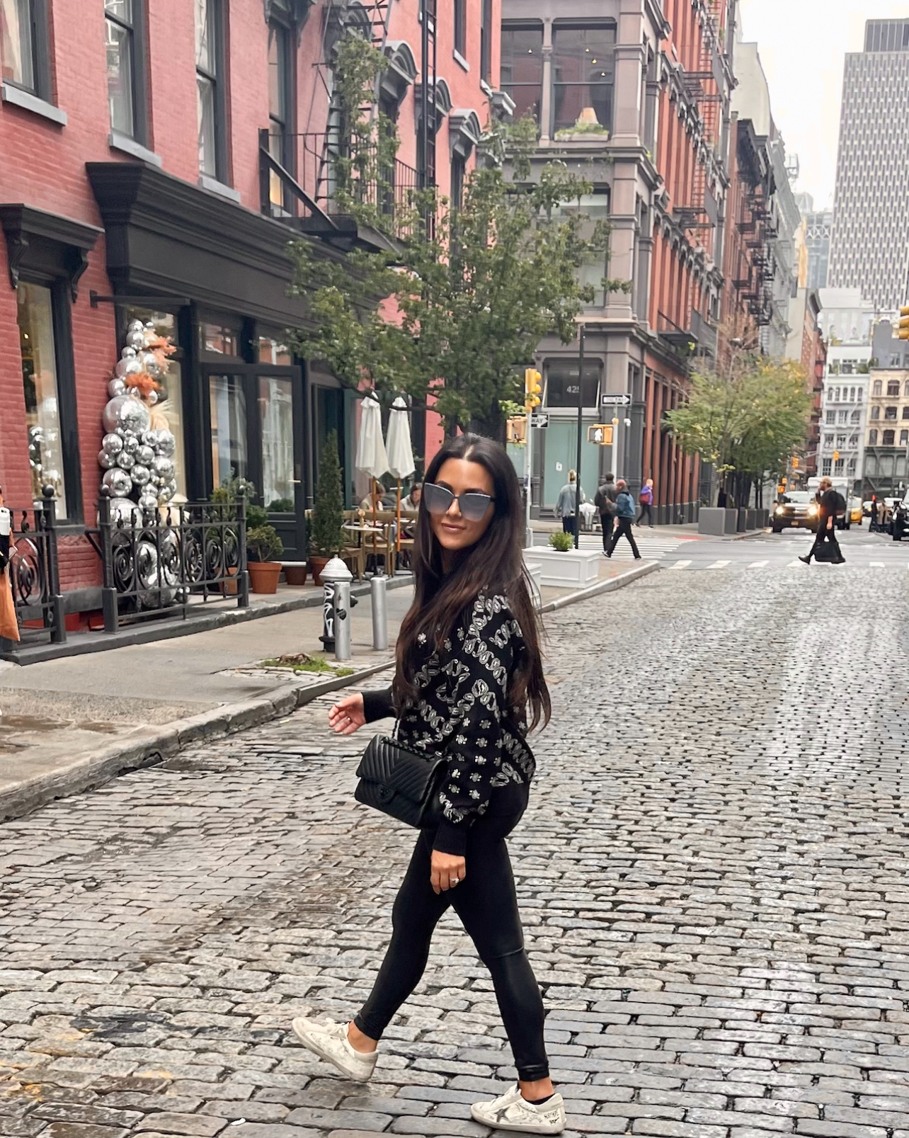 Advisor posing for an image while crossing the street in a city setting on a cloudy day.