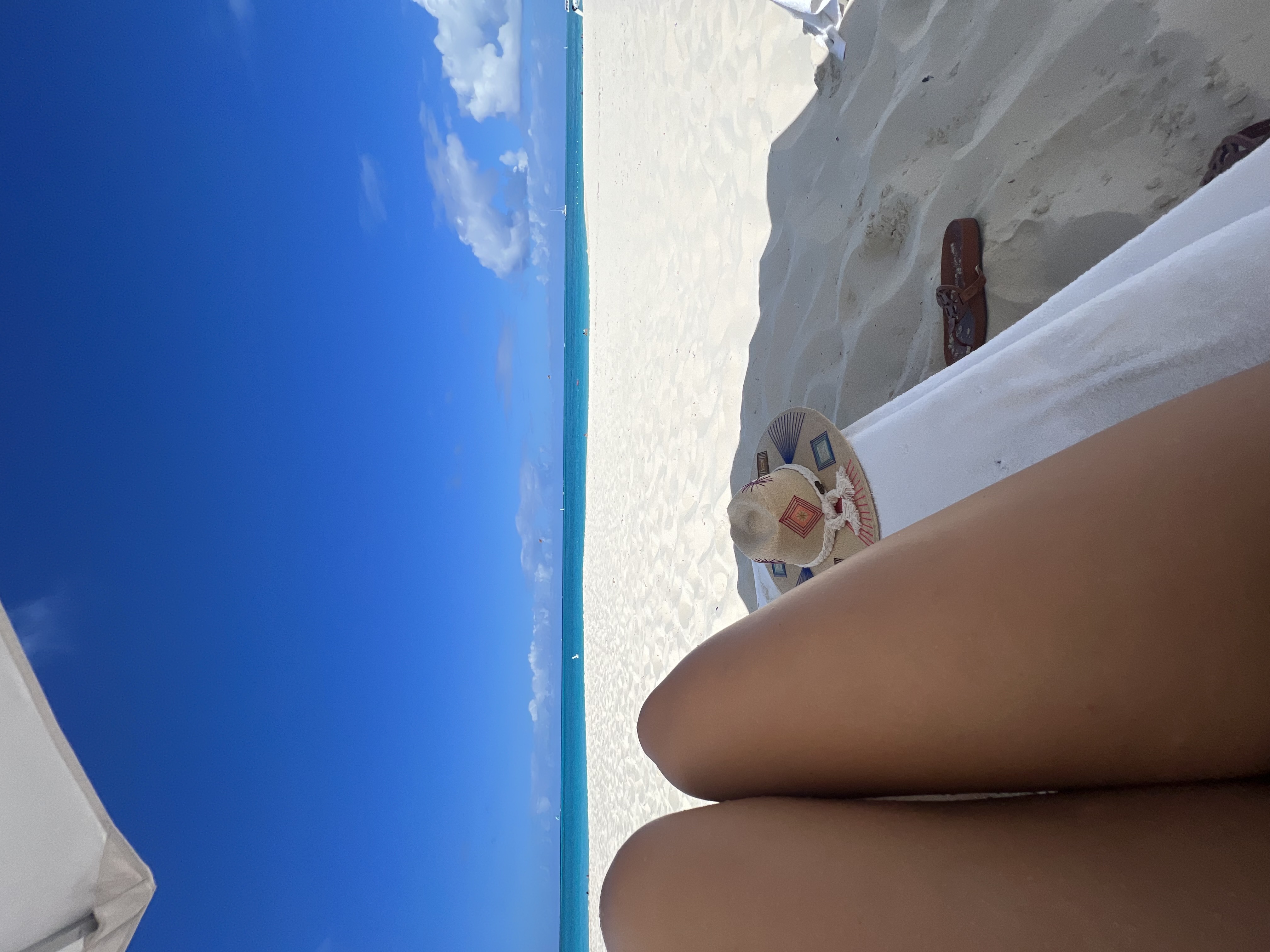Advisor lounging on the beach with the ocean in the distance.