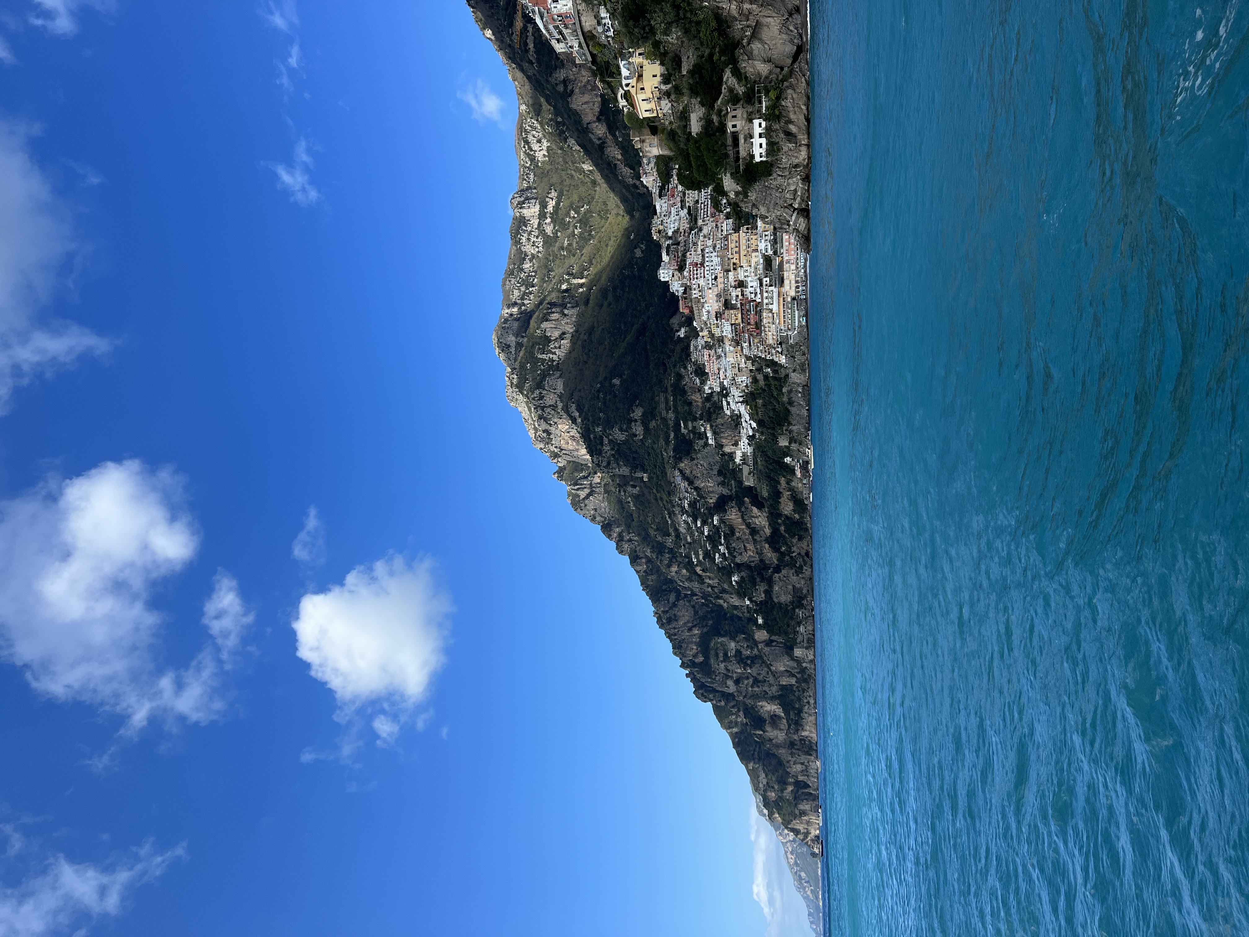 A view of the ocean with cliffs going into the water on a sunny day.