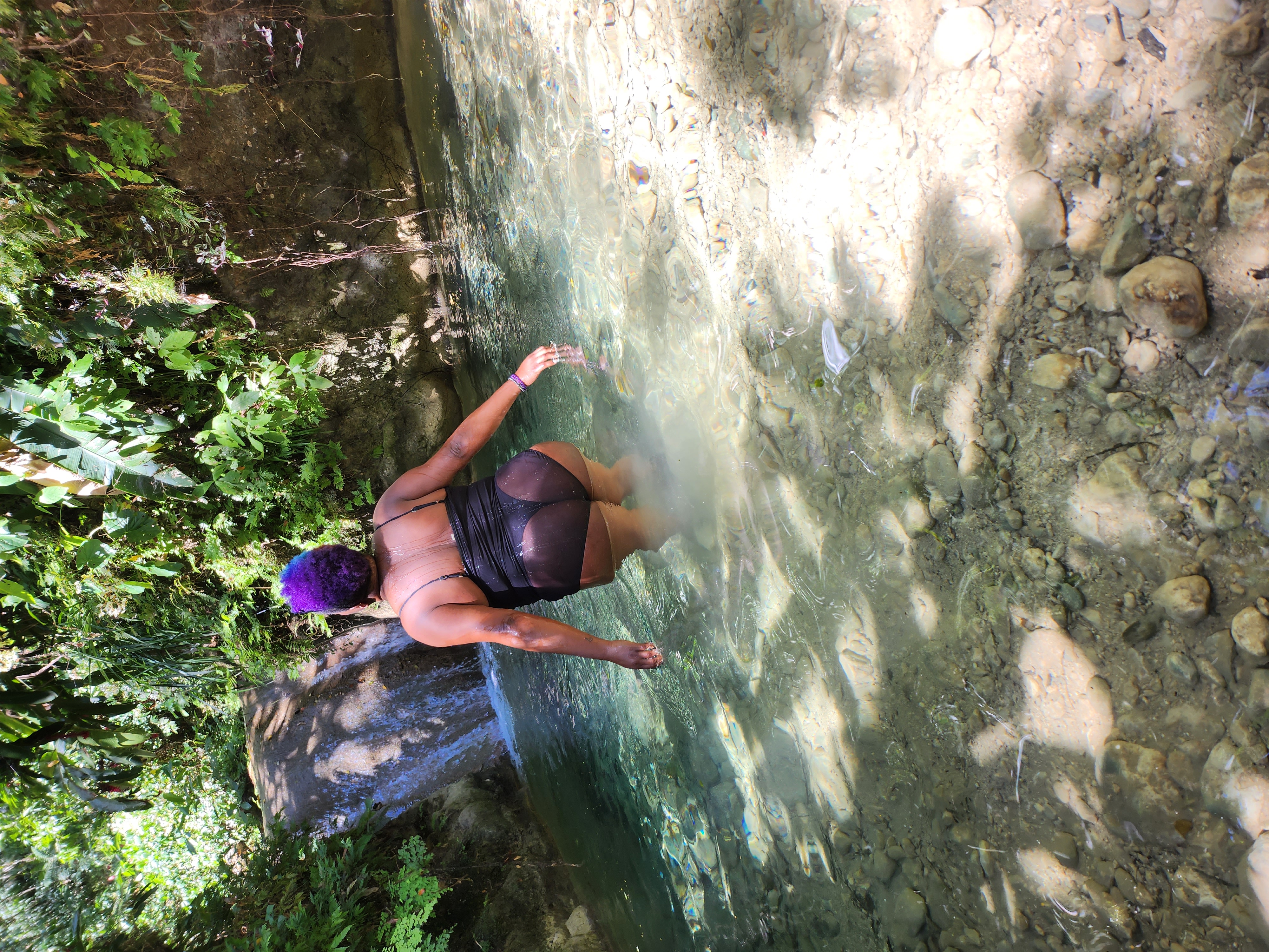 Advisor in a body of water with waterfall in the distance on a sunny day.