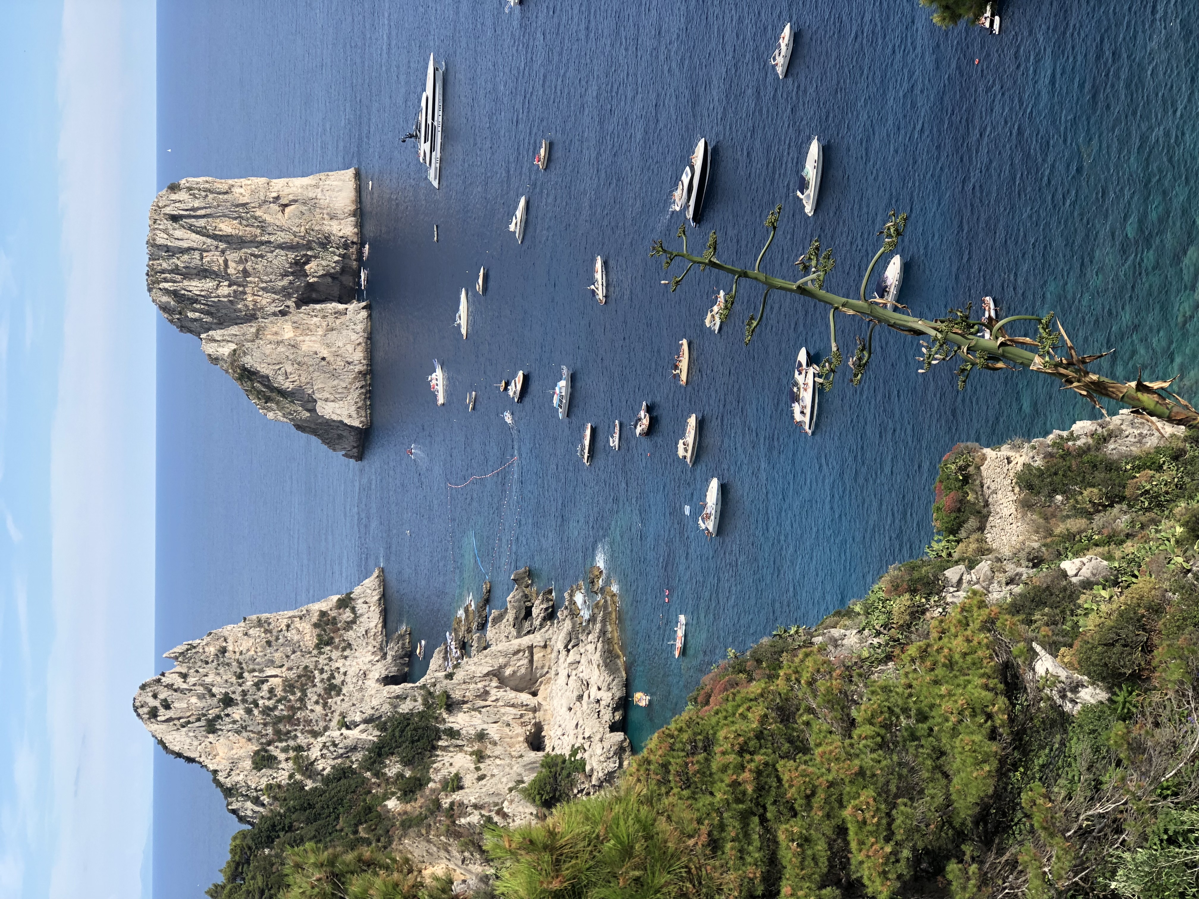 Aerial view of small boats at sea near Capri’s famous rock formations on a sunny day