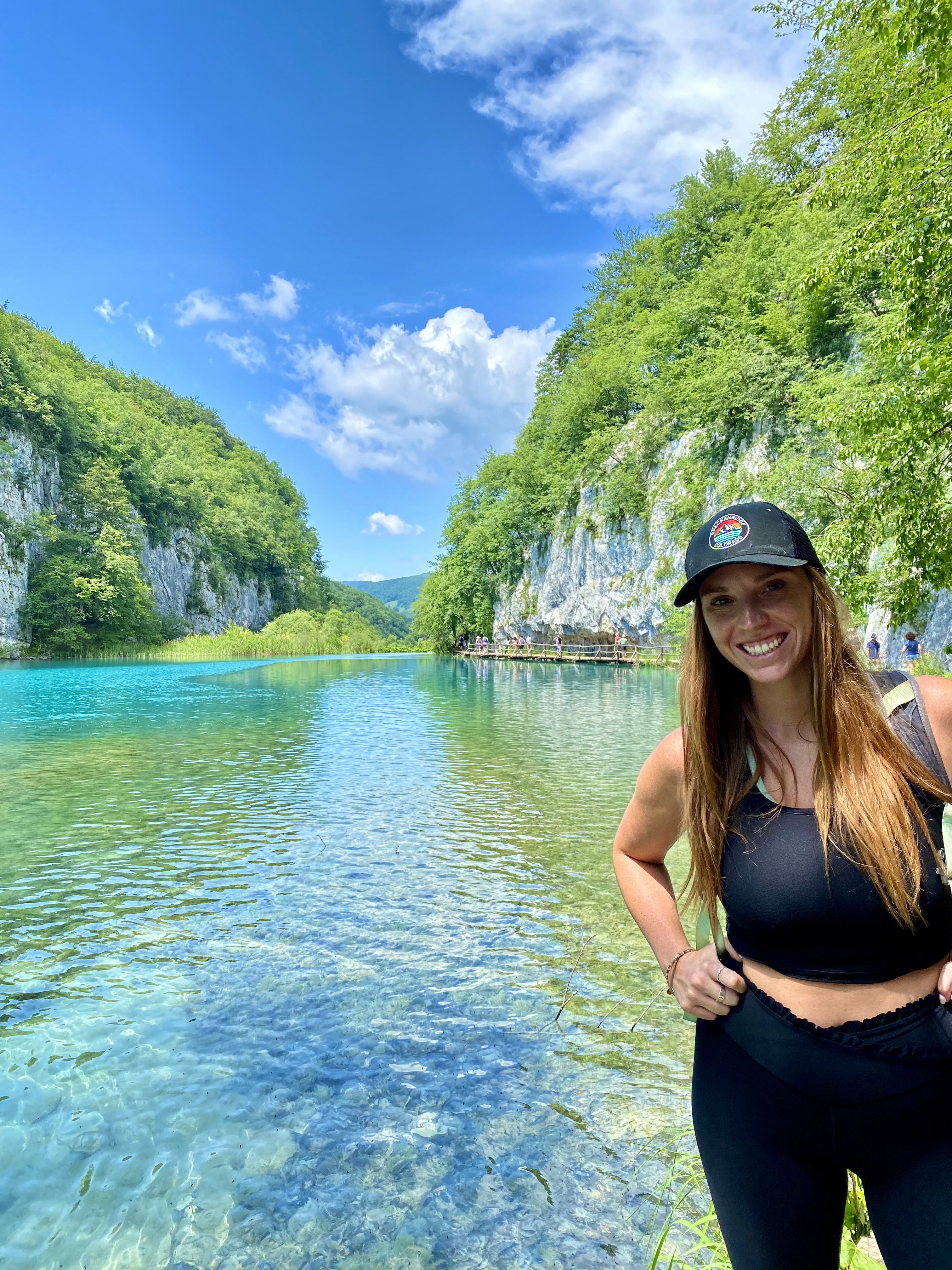 Advisor posing for a photo with a river and foliage in the distance.