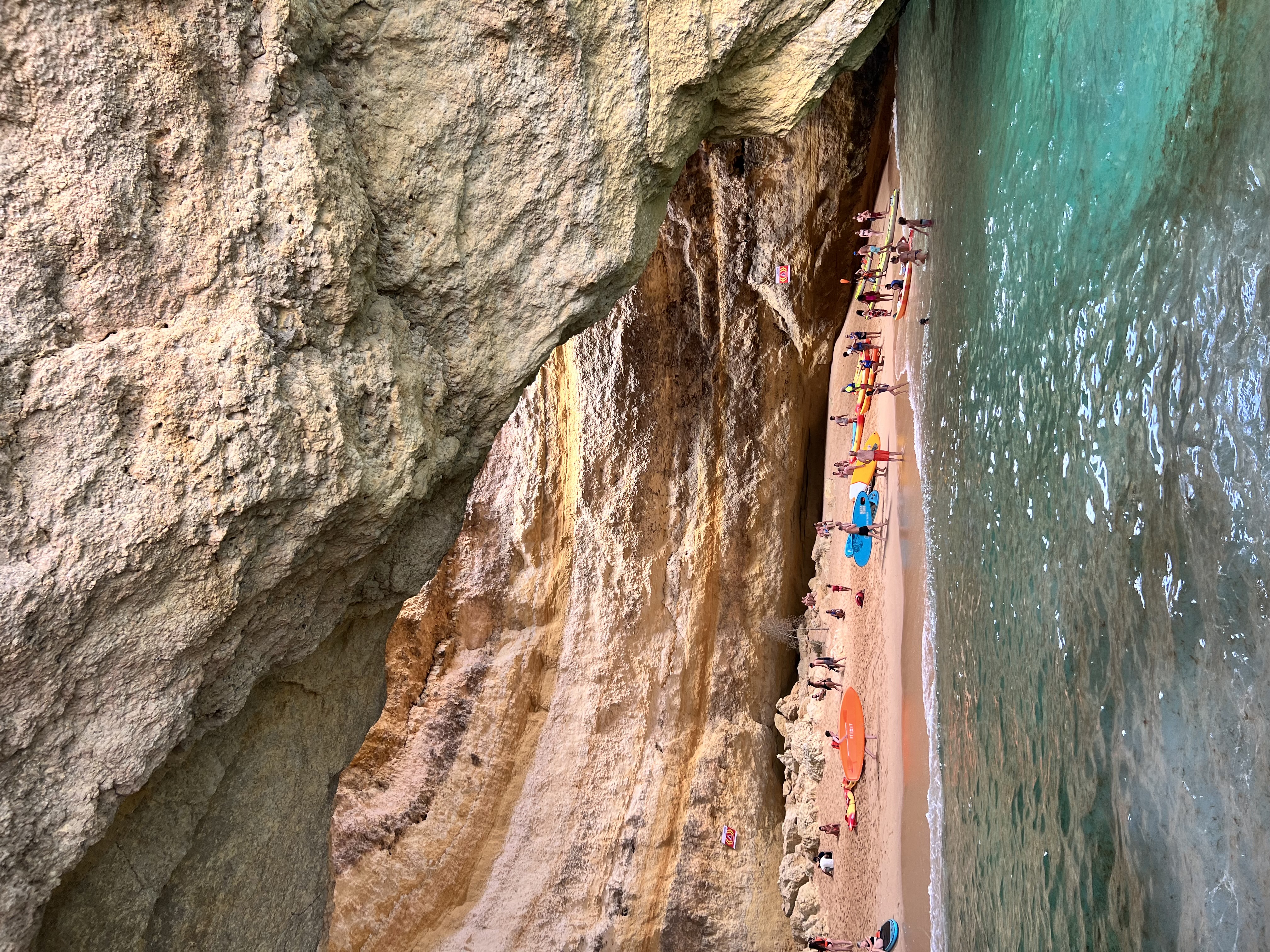 Beautiful view a secluded beach with many people hidden underneath large rock formations