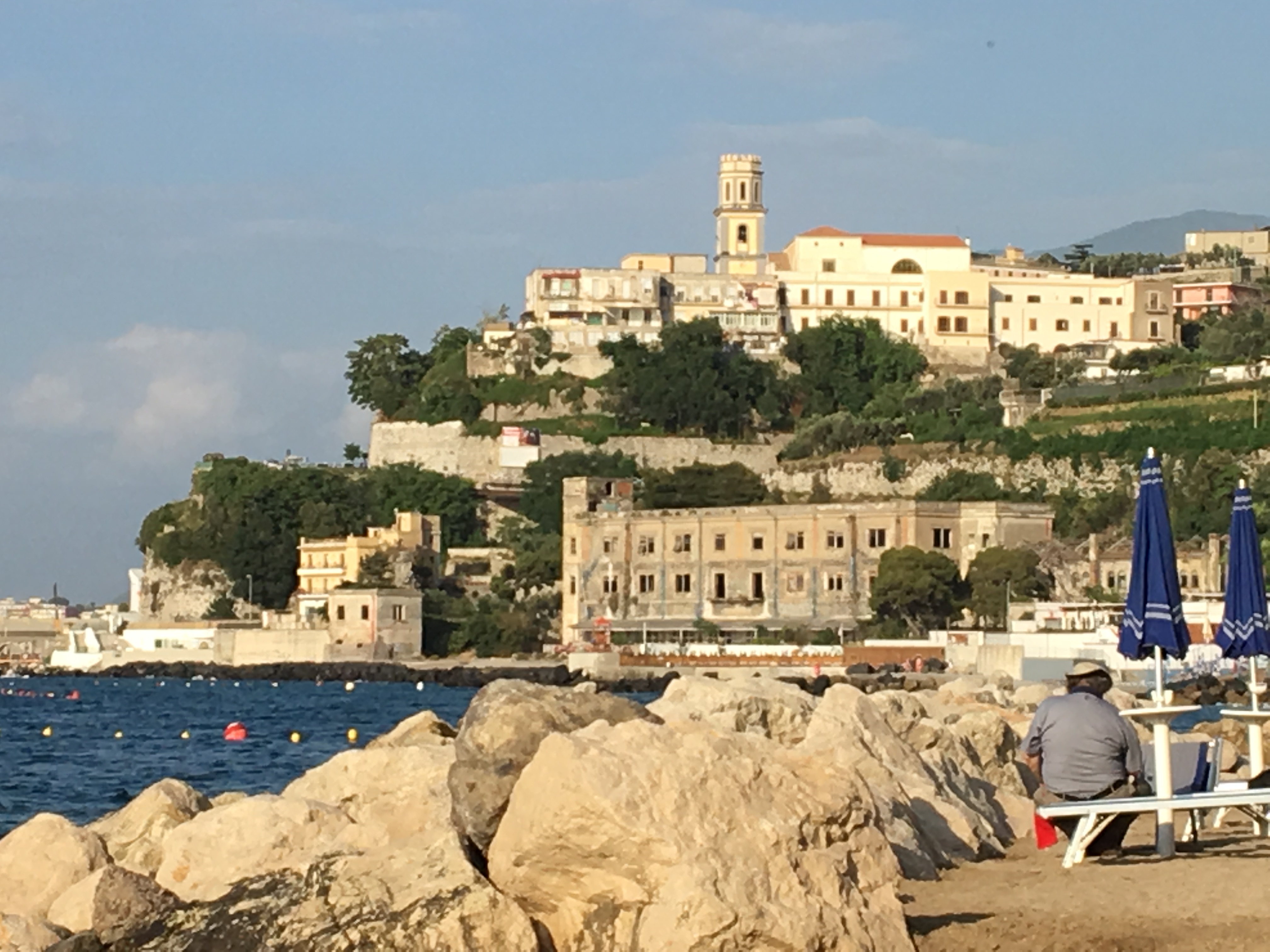 Historical buildings overlooking the ocean on a sunny day.