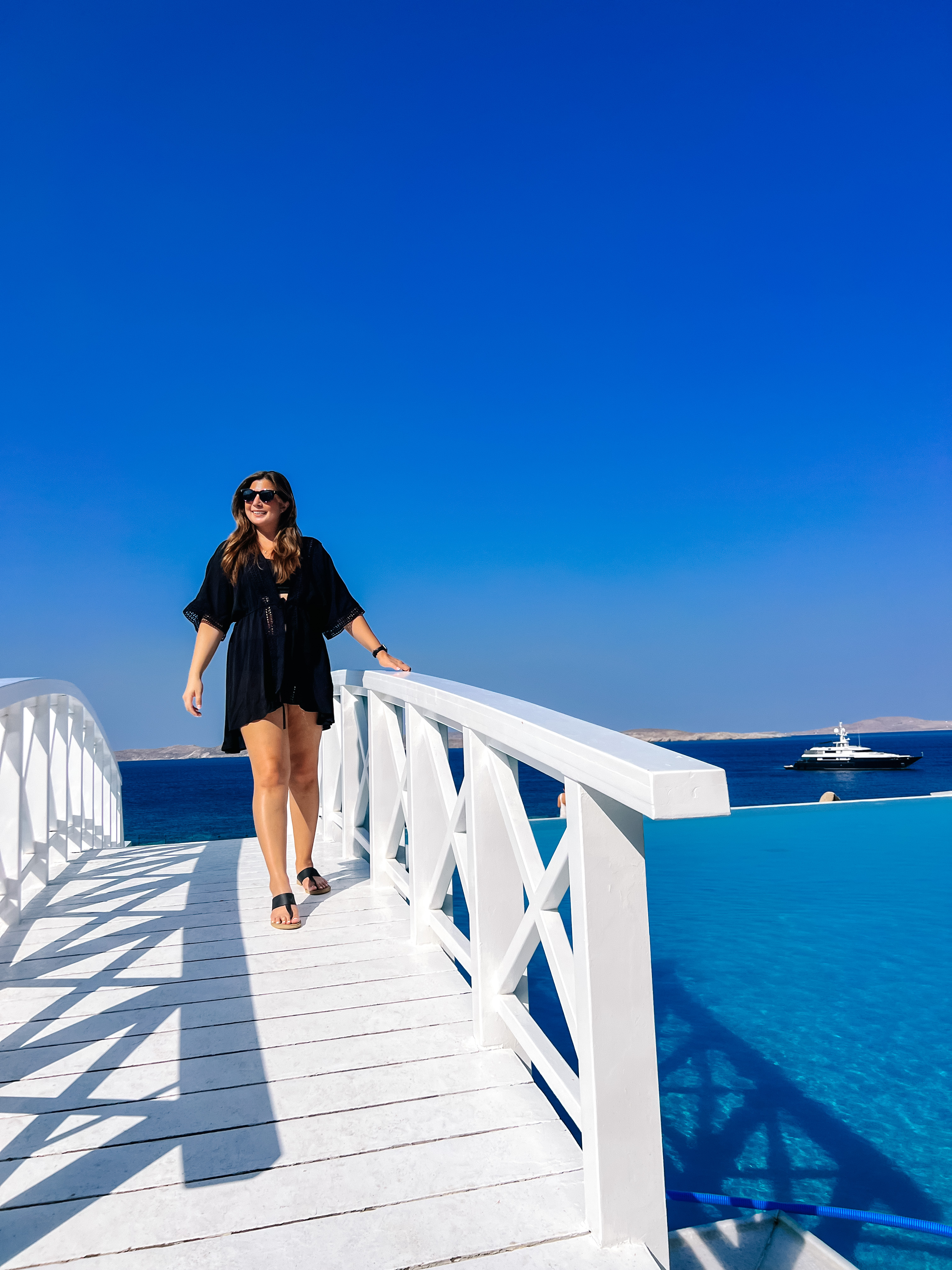 Advisor crossing a bridge with the ocean in the distance on a sunny day.