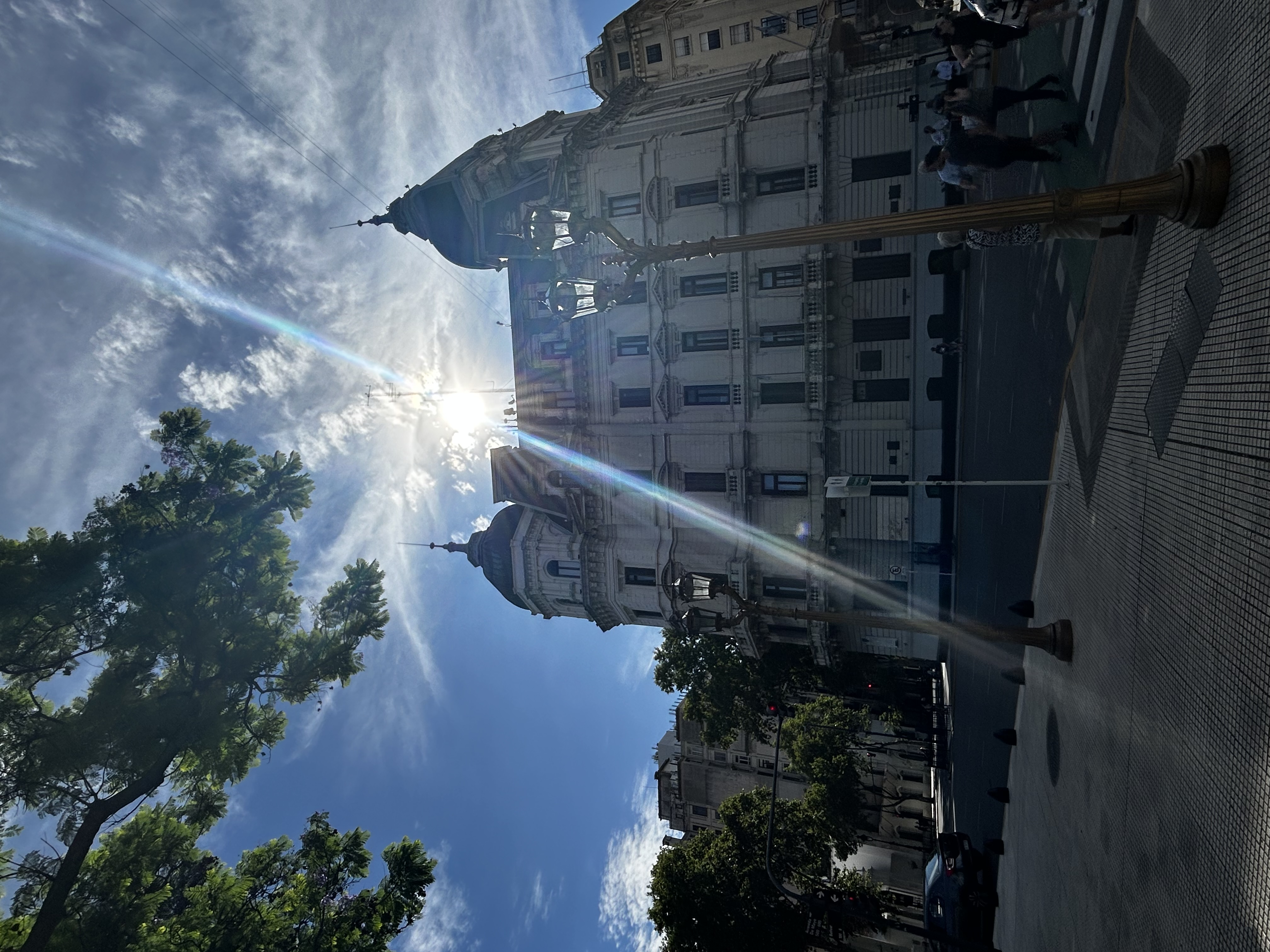 Pretty view from the road of an old building with many windows with the sun shining over the top