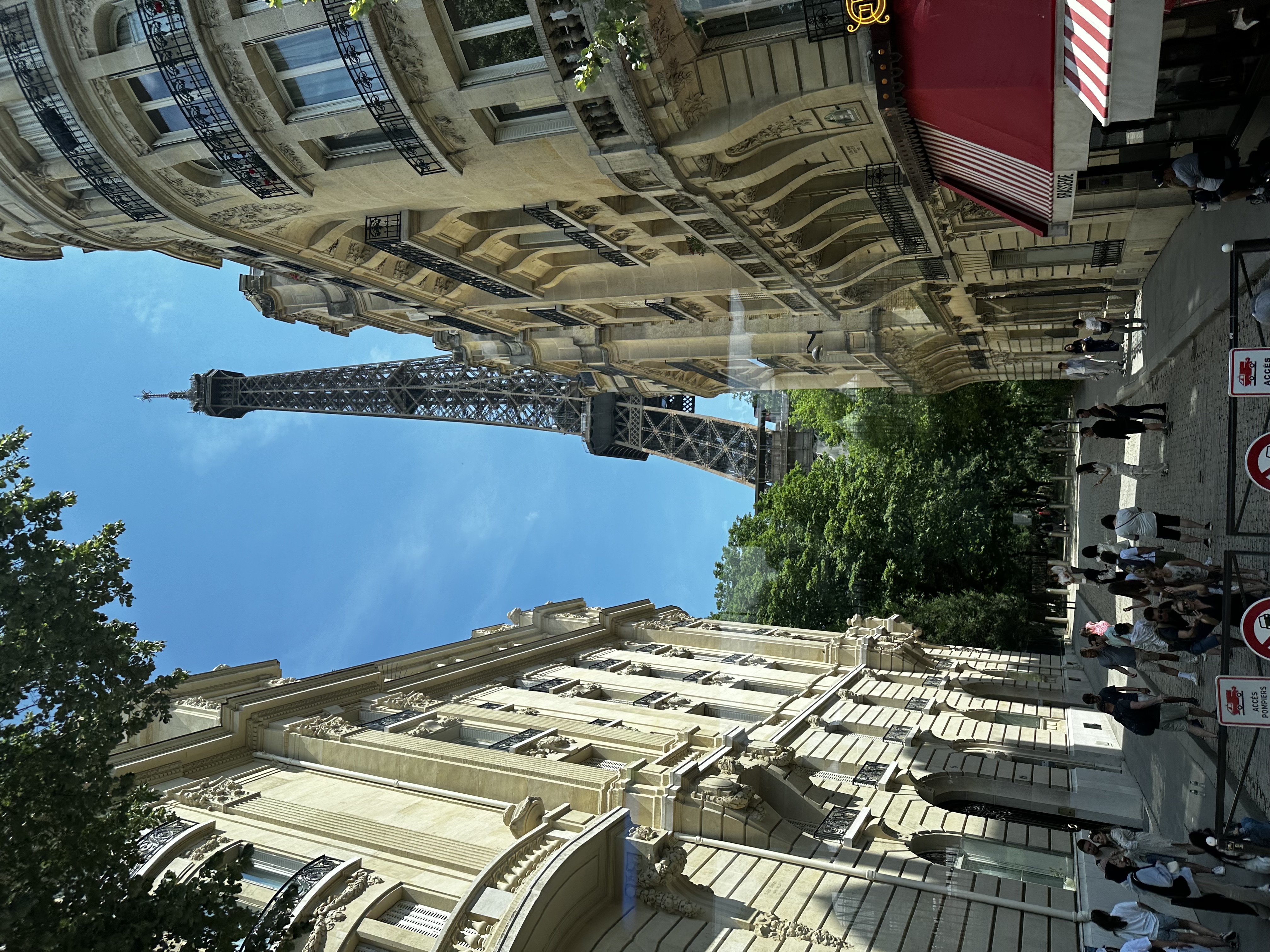 Pretty view of a street in Paris with the Eiffel Tower visible in the distance on a sunny day