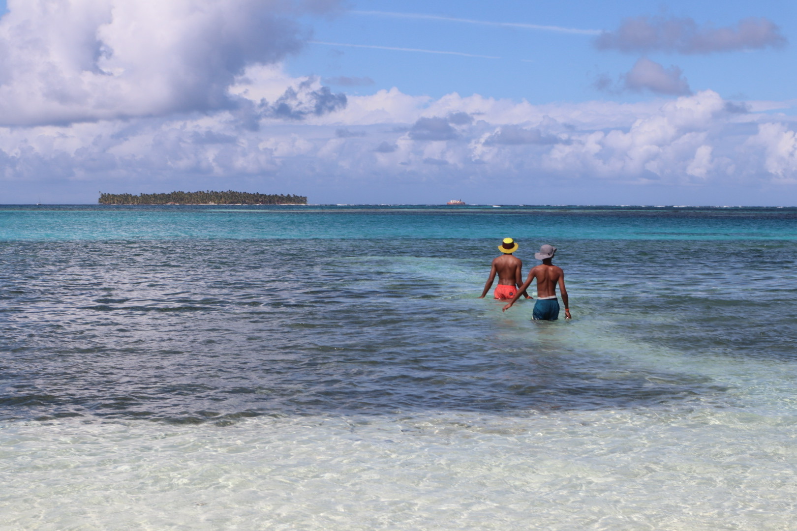 Walking into the crystal clear sea on a sunny day.
