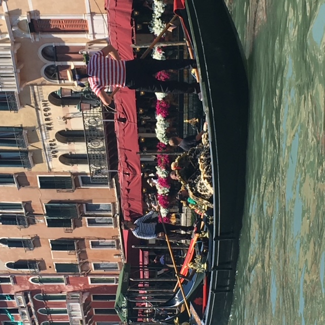 A gondola floating across the river in Venice.