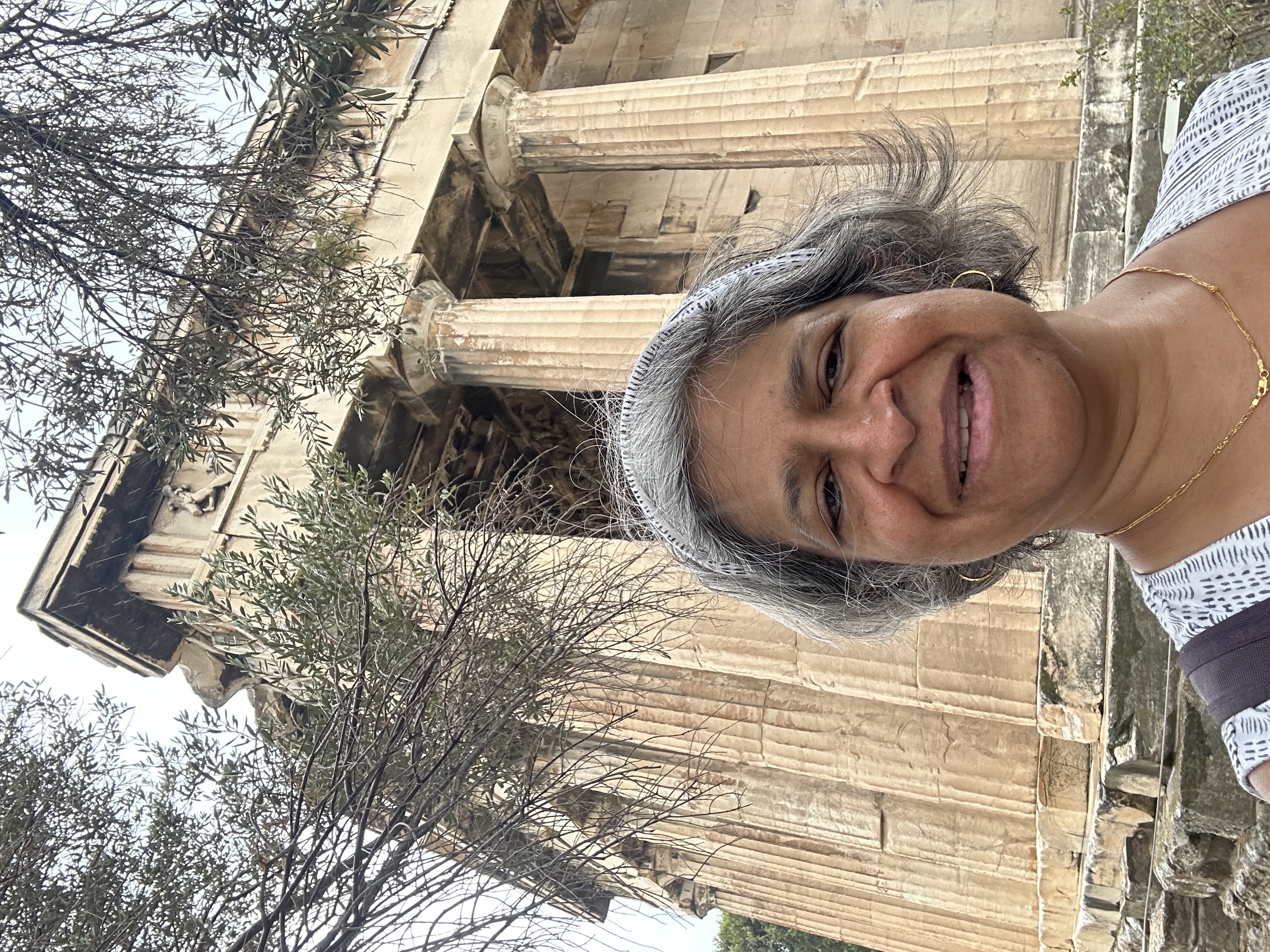 Advisor posing in front of ruins on a sunny day.