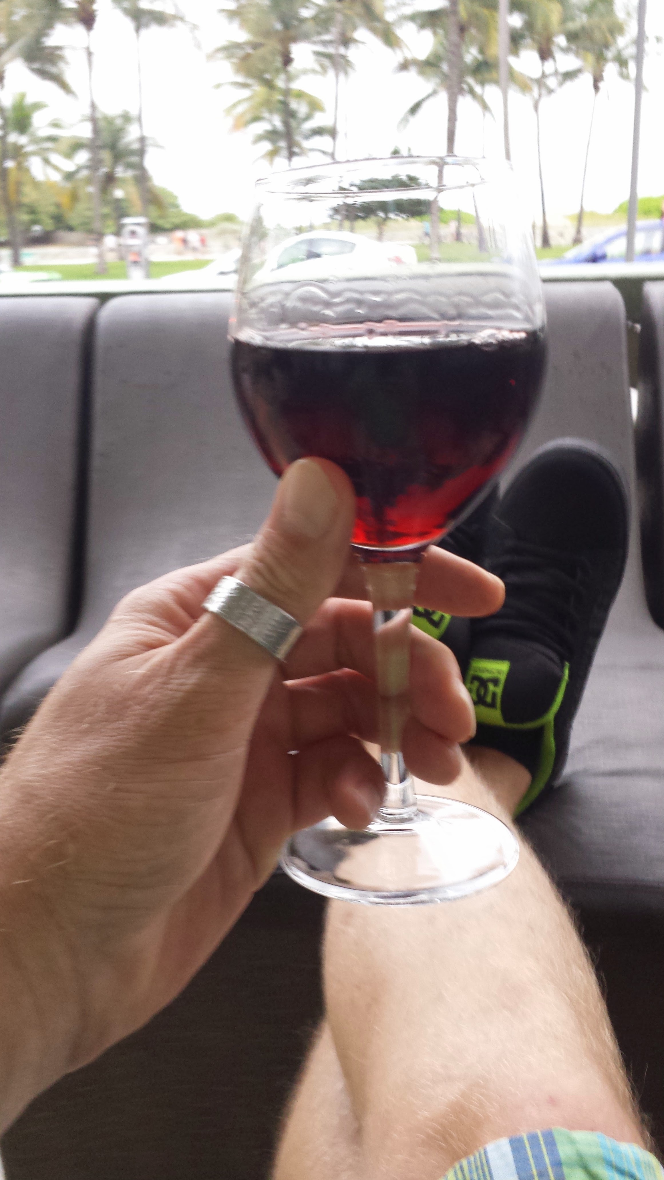 A close-up image of a hand holding a glass of red wine