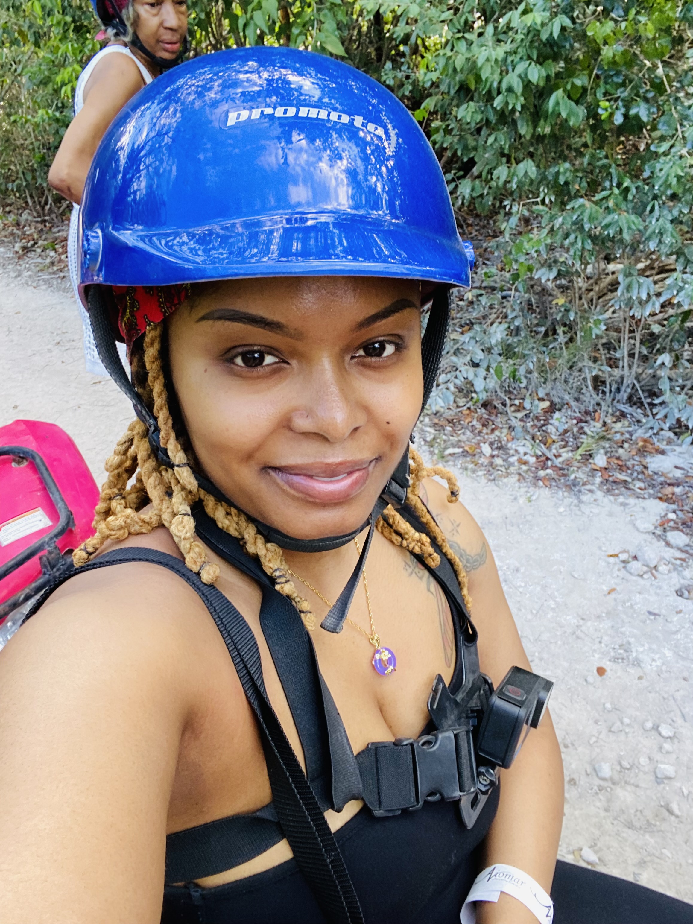 Ebony in a blue helmet taking a selfie outdoors