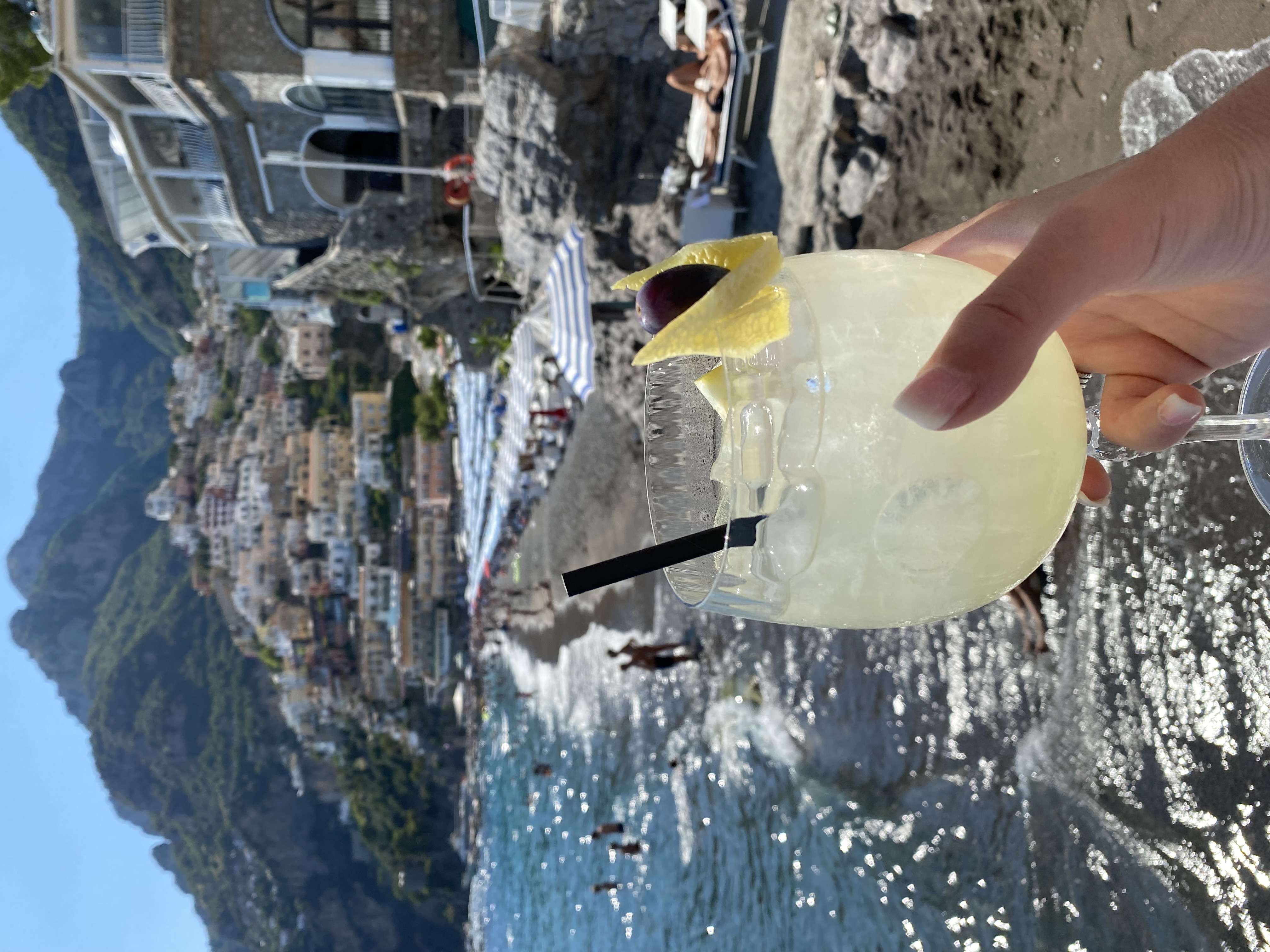 Cocktail with beach views and hills in the back.