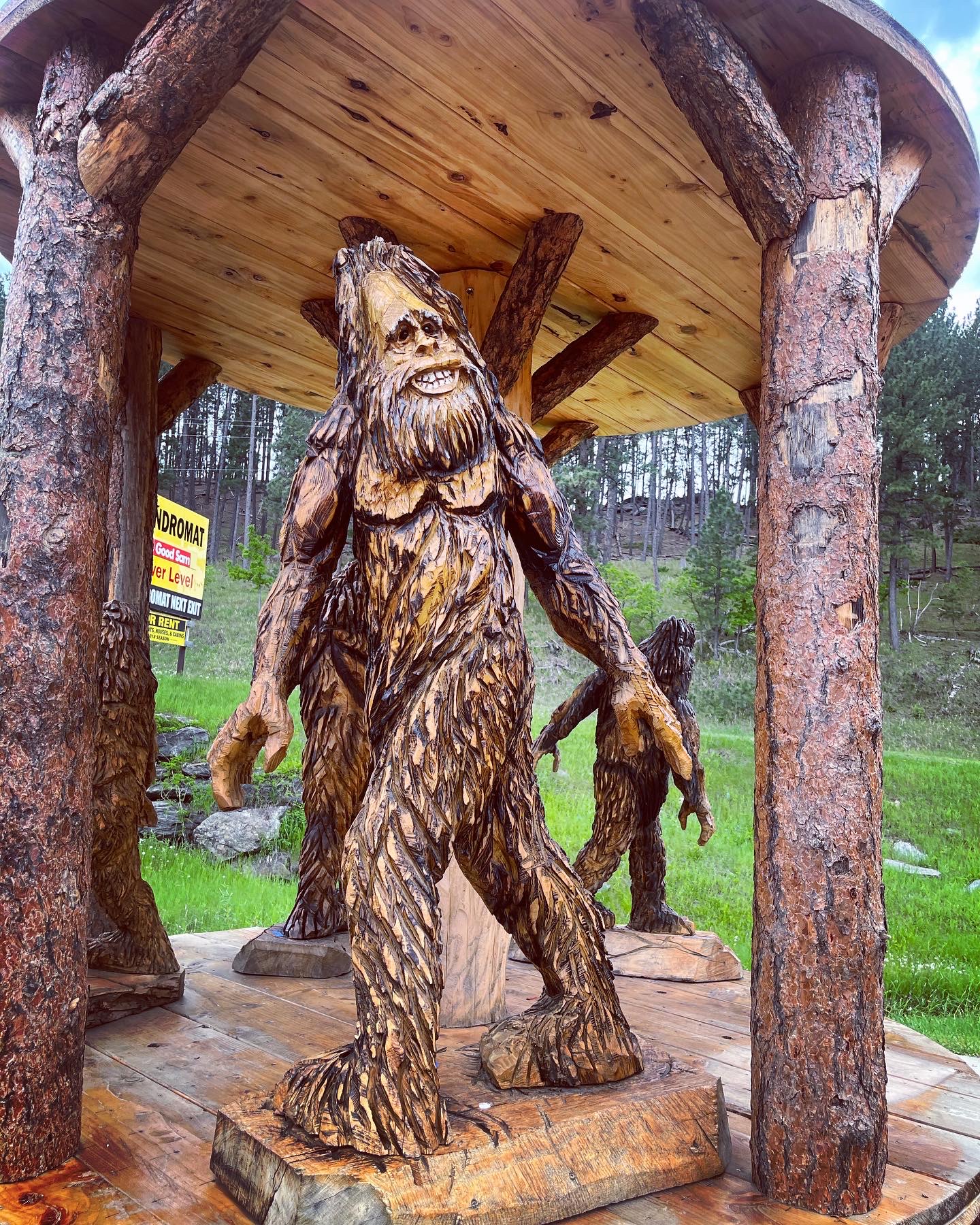 View of a wooden sculpture resembling Big Foot set underneath a wooden gazebo structure