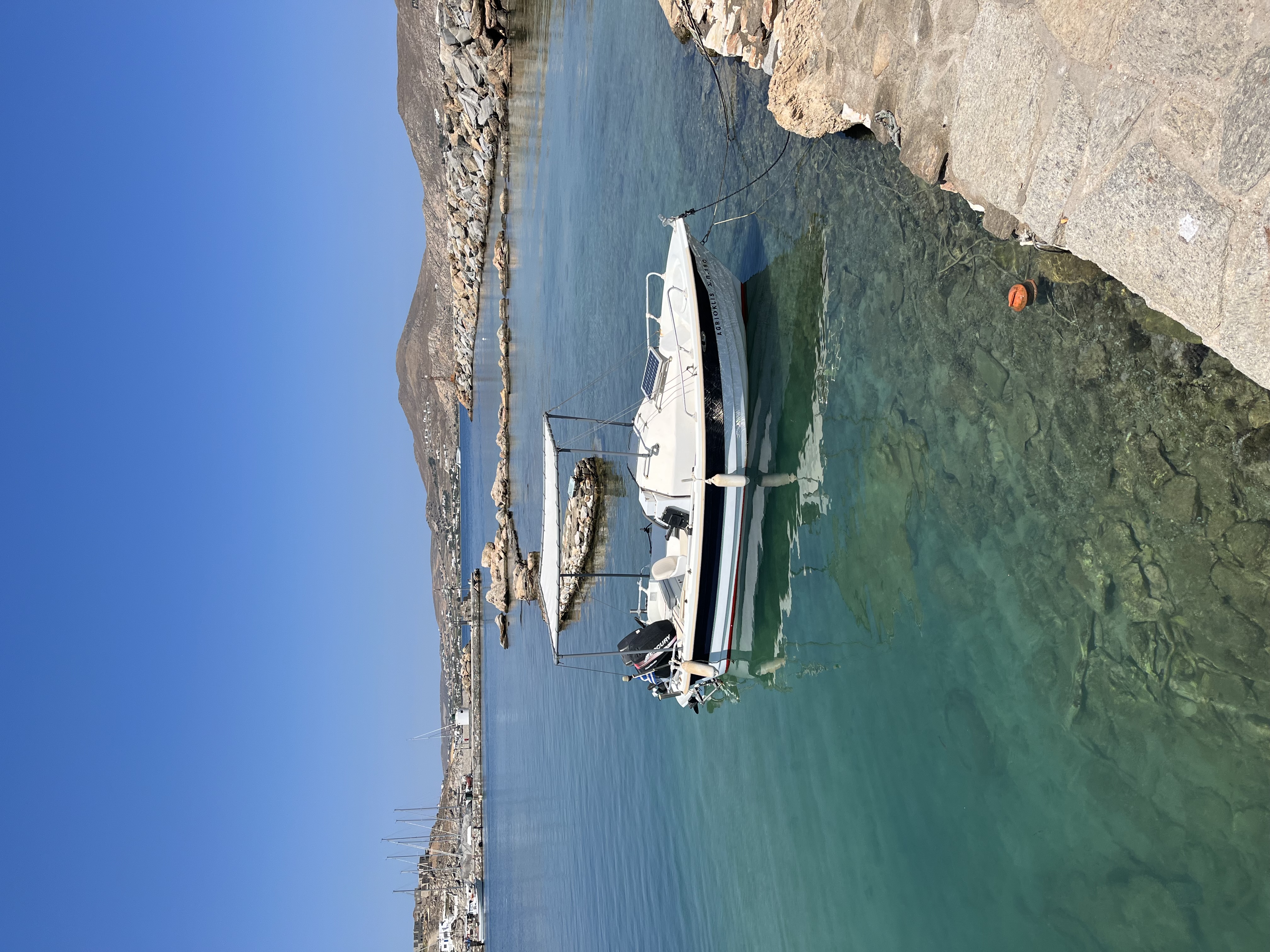 A boat in the water surrounded by mountains during the daytime.
