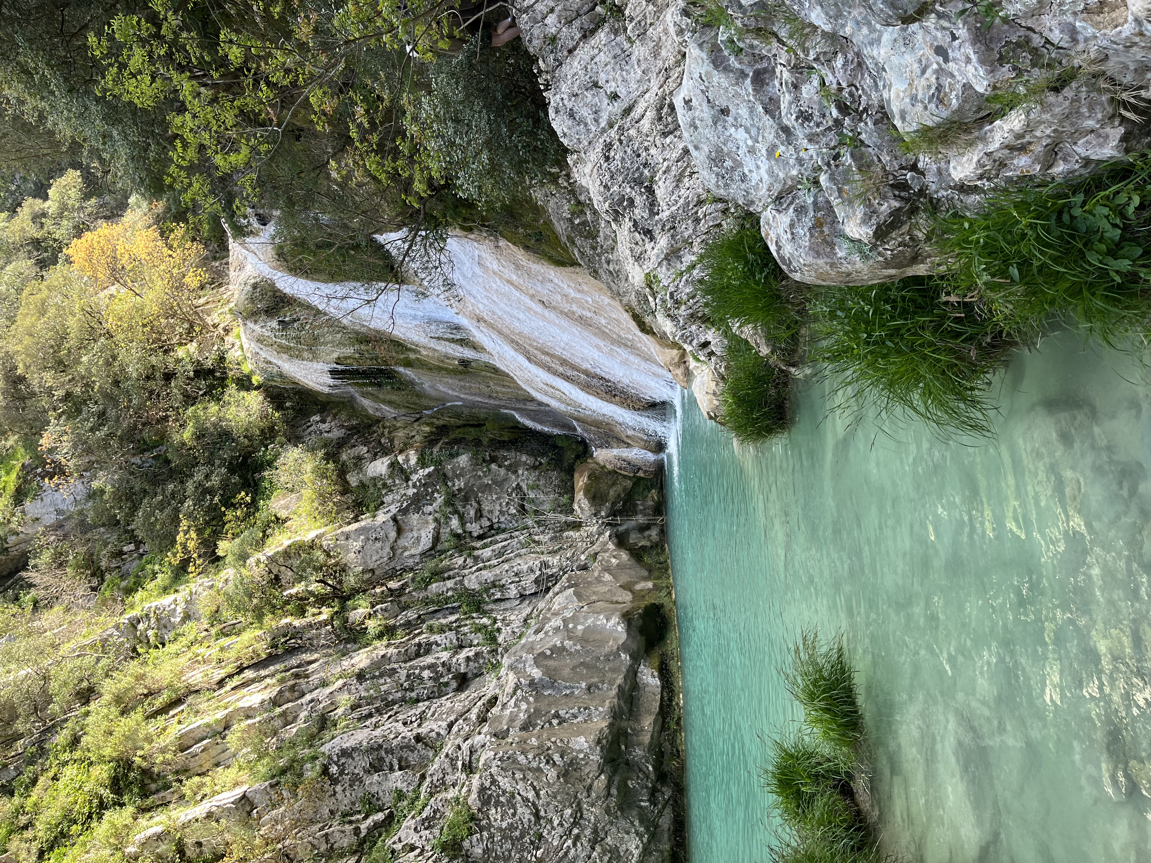A waterfall surrounded by the mountains.