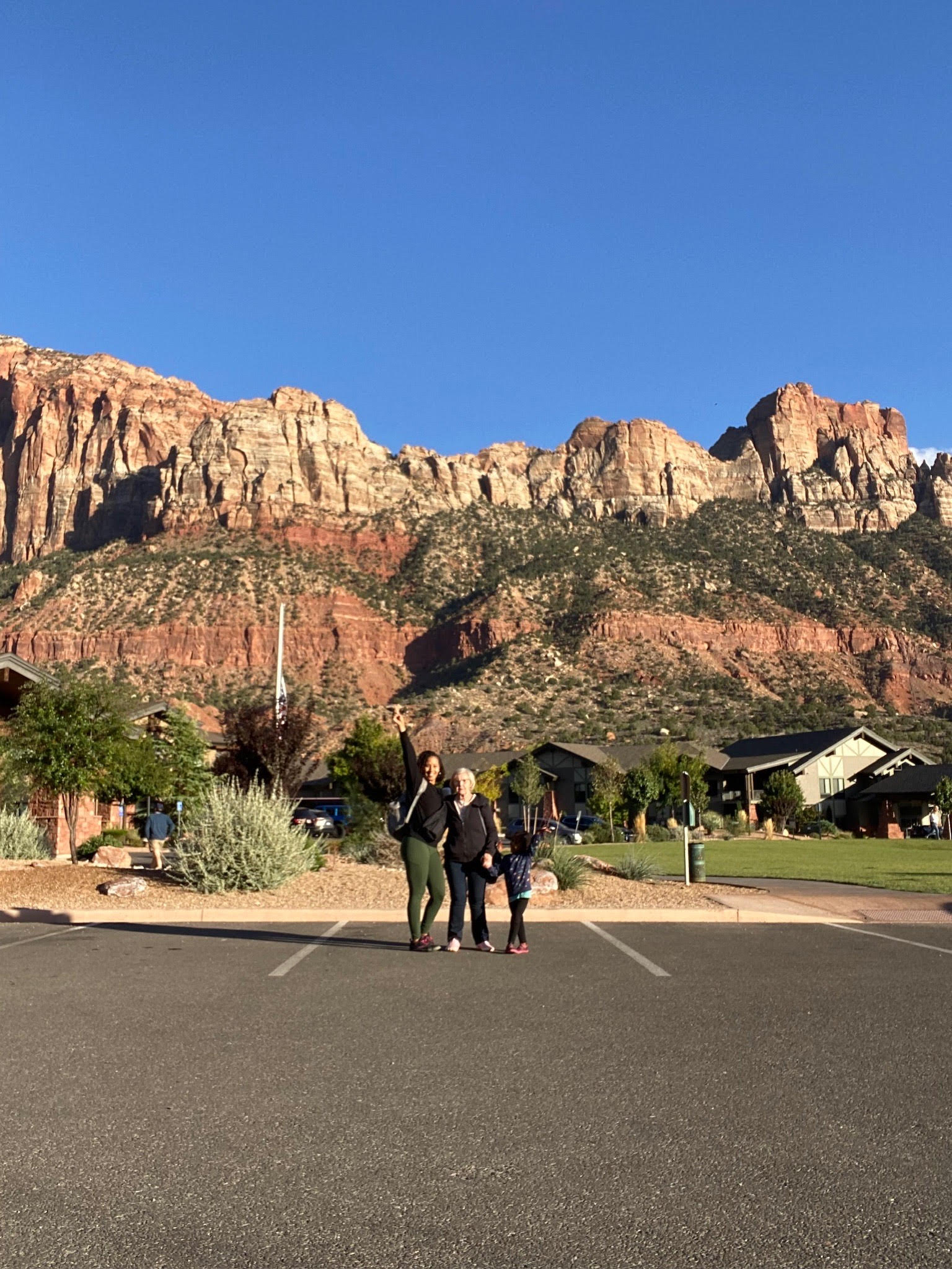 Advisor posing with her family and the base of a mountain range on a sunny day.